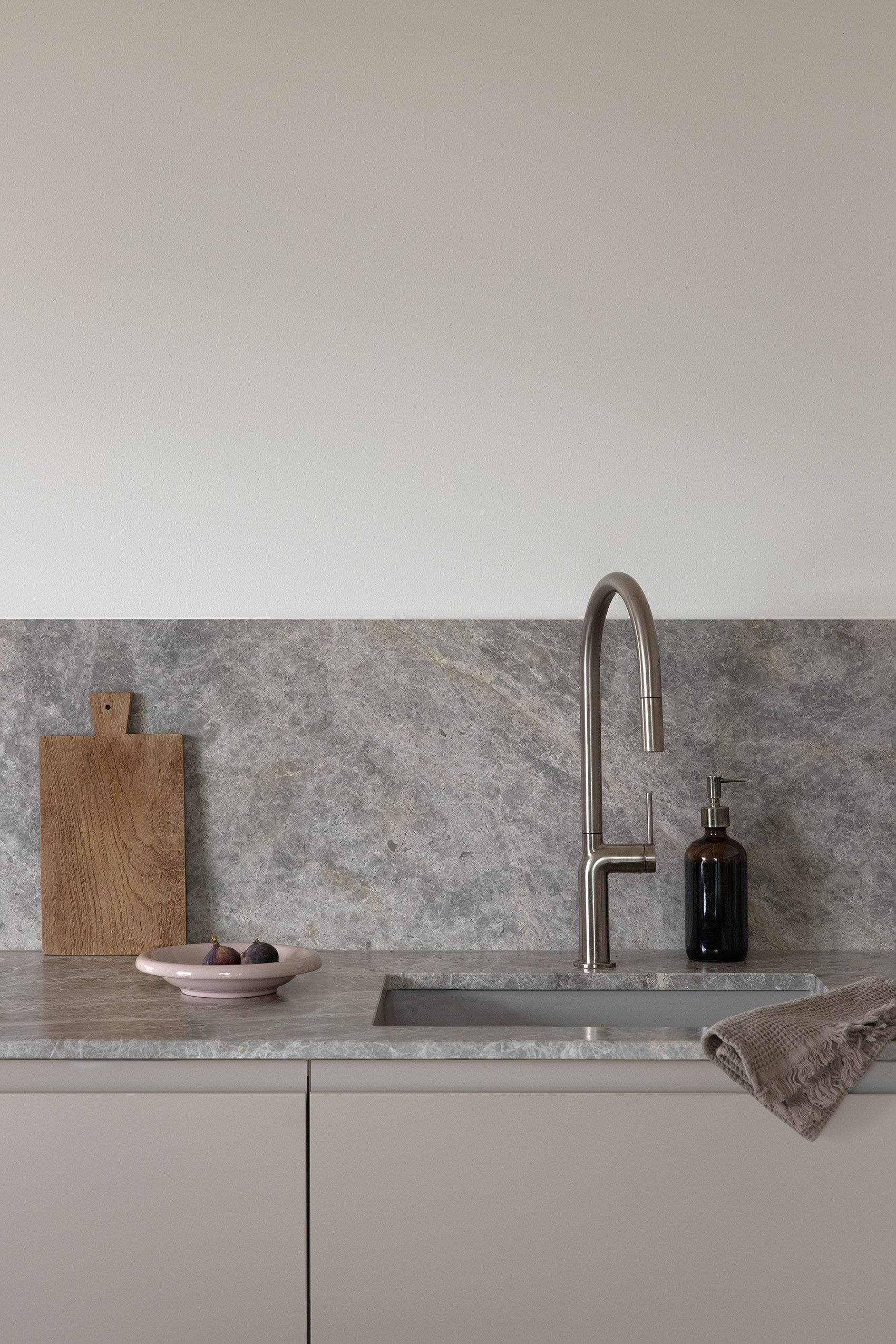 A custom cashmere grey kitchen with warm grey marble worktop and oak-clad island, Spandau Berlin