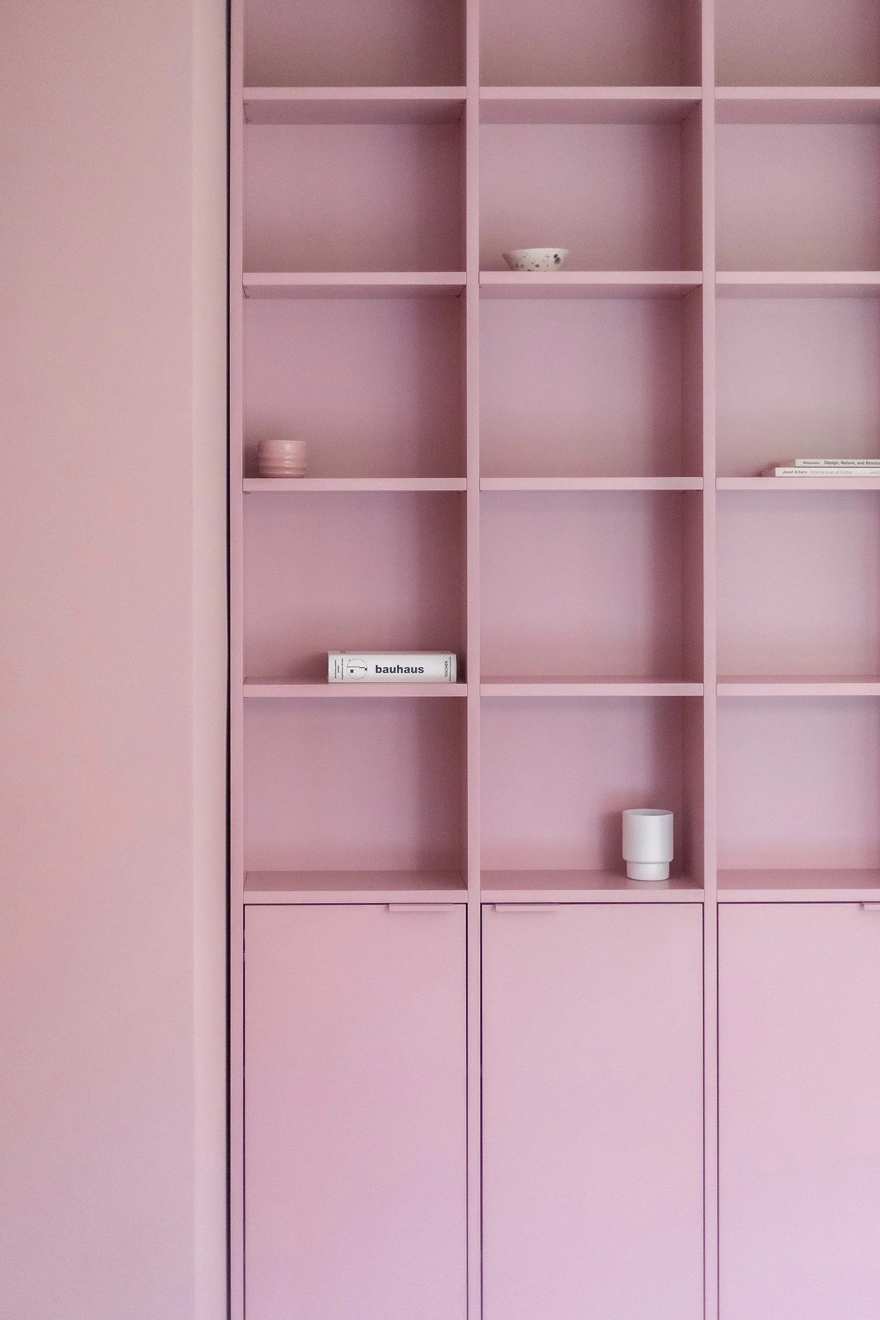 A custom built-in bookshelf in Farrow & Ball Cinder Rose, Mitte Berlin