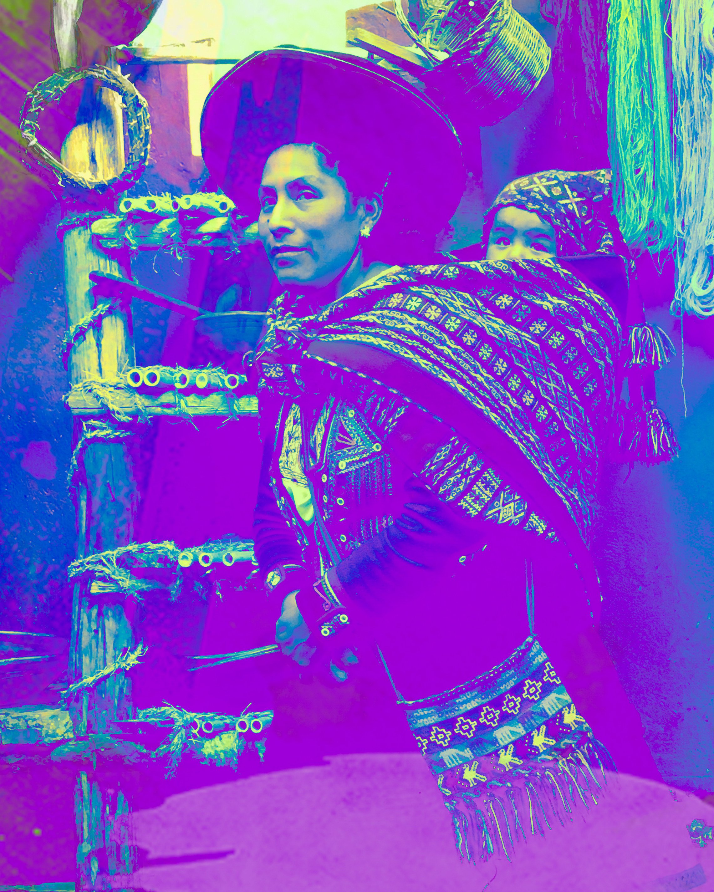 Two women in traditional, colorful, patterned clothing, standing indoors near woven baskets and decorative items.