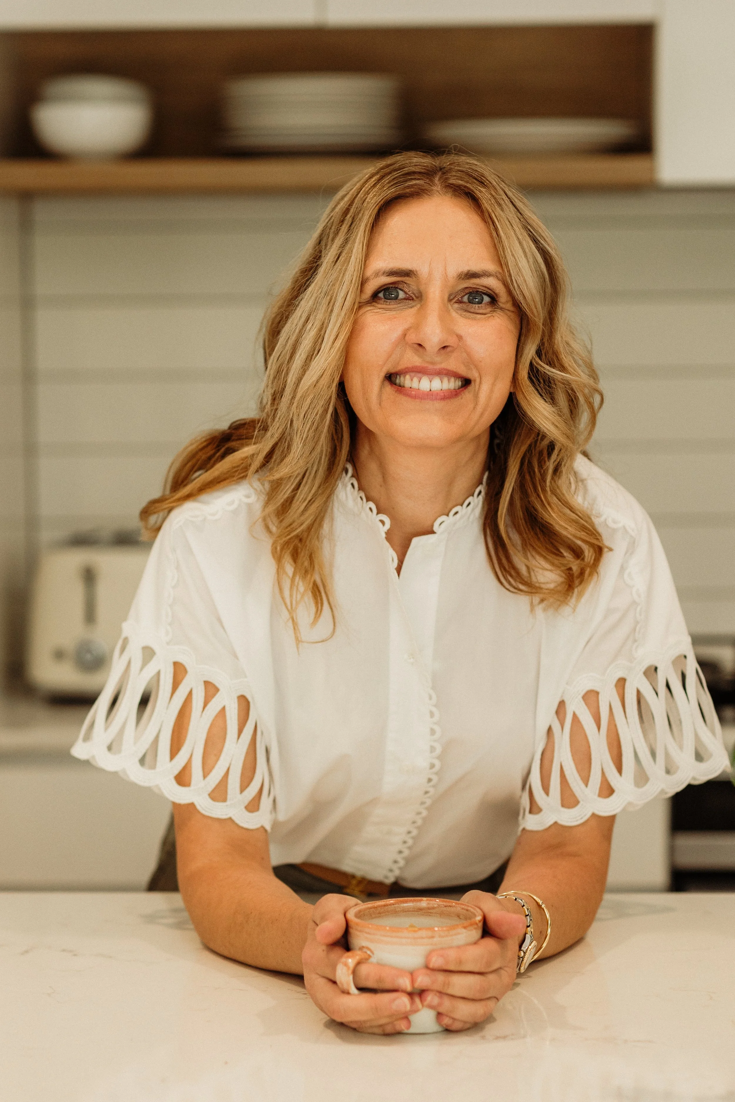Joanna Mitolo smiling and holding a warm drink