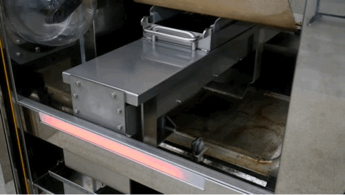 A commercial conveyor belt with a metal surface and a digital display, likely used for sorting or processing items in a food or packaging facility.