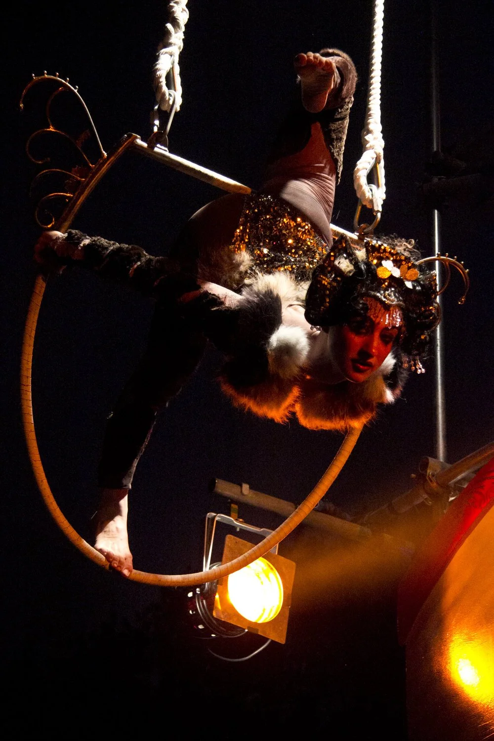 aerial hoop performer wearing furry leotard and sparkly headpiece