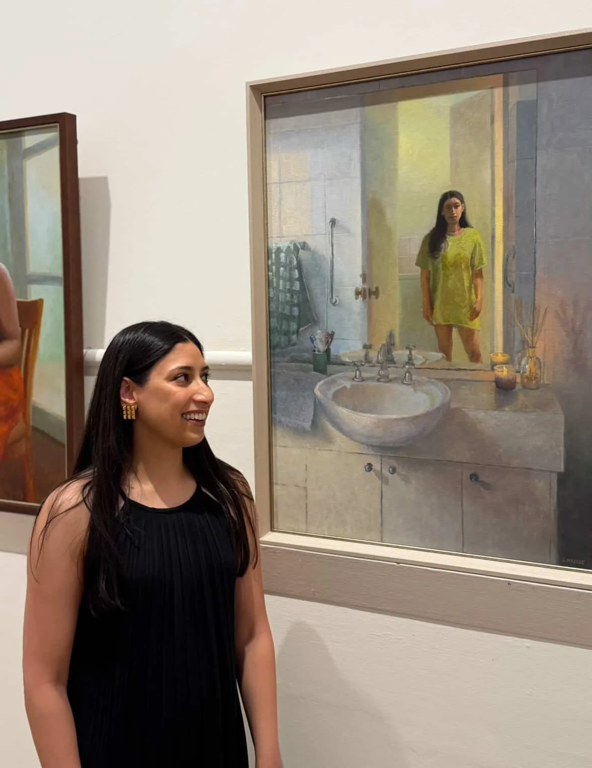Melbourne portrait artist Swathi Madike beside her self portrait at the Victorian Artists Society exhibition