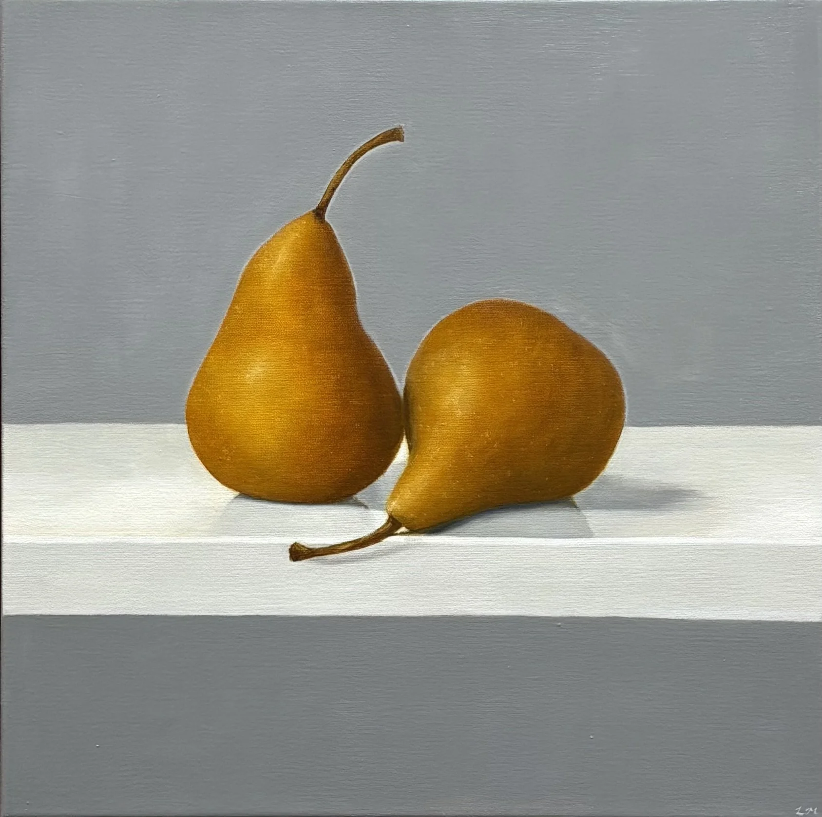 Two yellow pears, one upright and one lying on its side, placed on a white shelf against a light gray background.