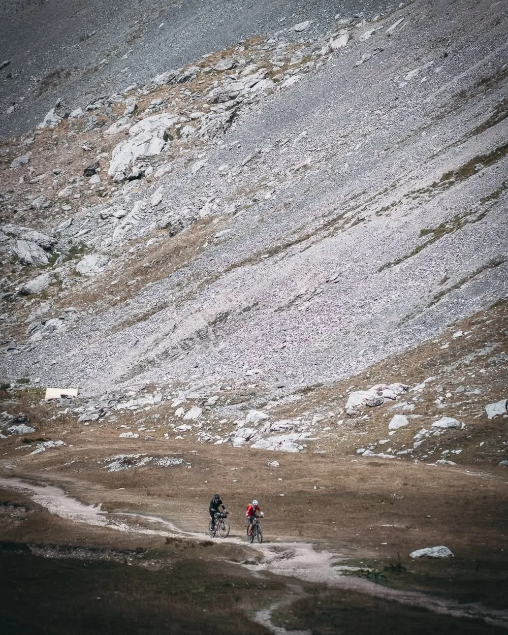 Col des Rochilles, surrounded by the jagged peaks of the Massif des Cerces. With the Galibier in the legs, the road turns into this long military gravel track, climbing toward the high mountain lakes. Where soon after, a tough hike-a-bike begins. The