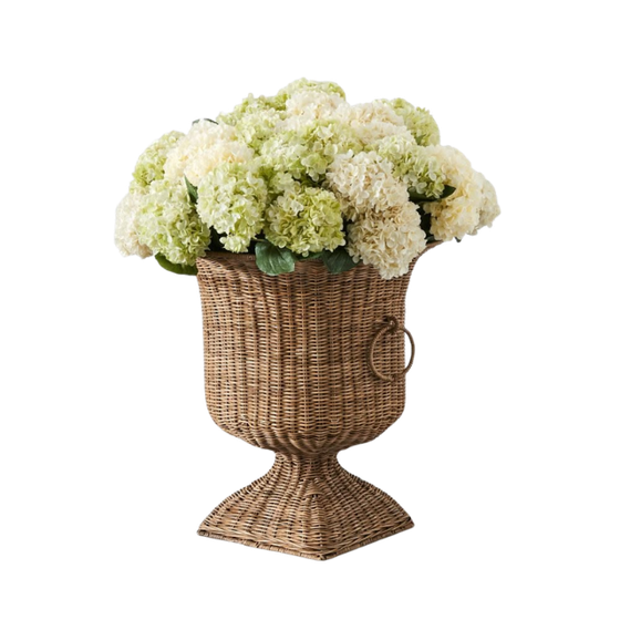 A basket-shaped vase filled with white and beige hydrangea flowers.