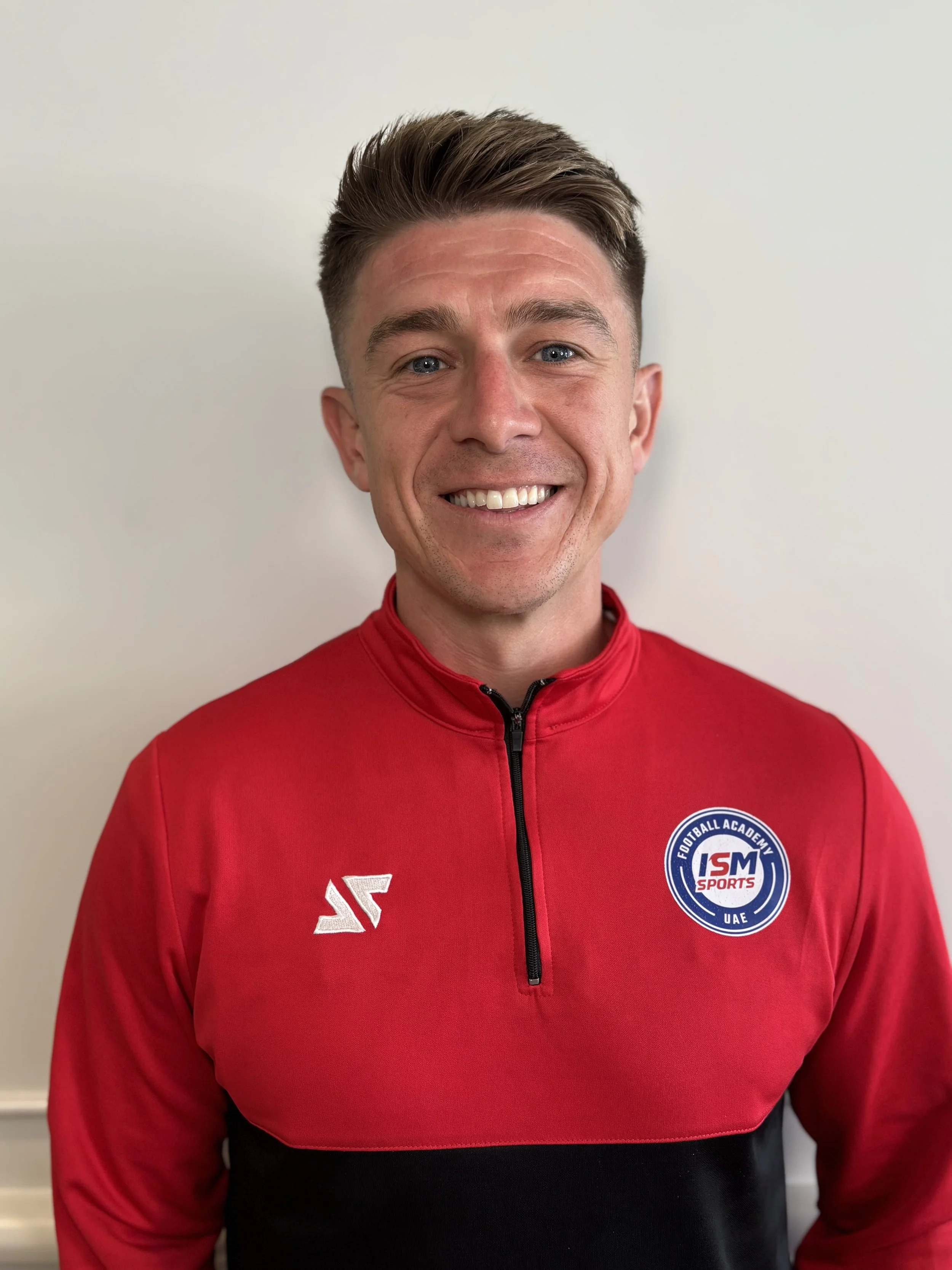 Person wearing a black polo shirt with the ISM Sports logo.