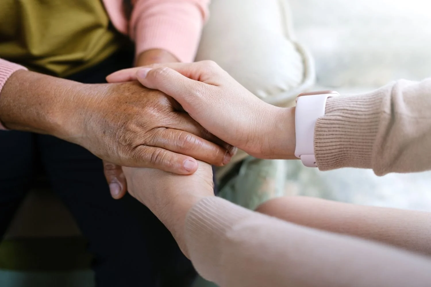 Younger hand gently holding an older hand in Dorset move support