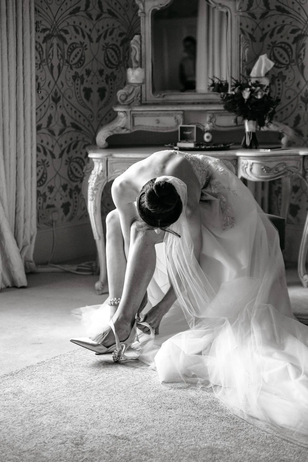 Bride fastening her shoes before the ceremony