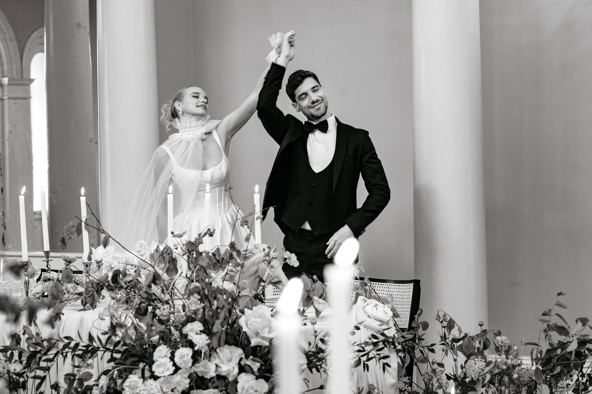Couple dancing around their dinner table.