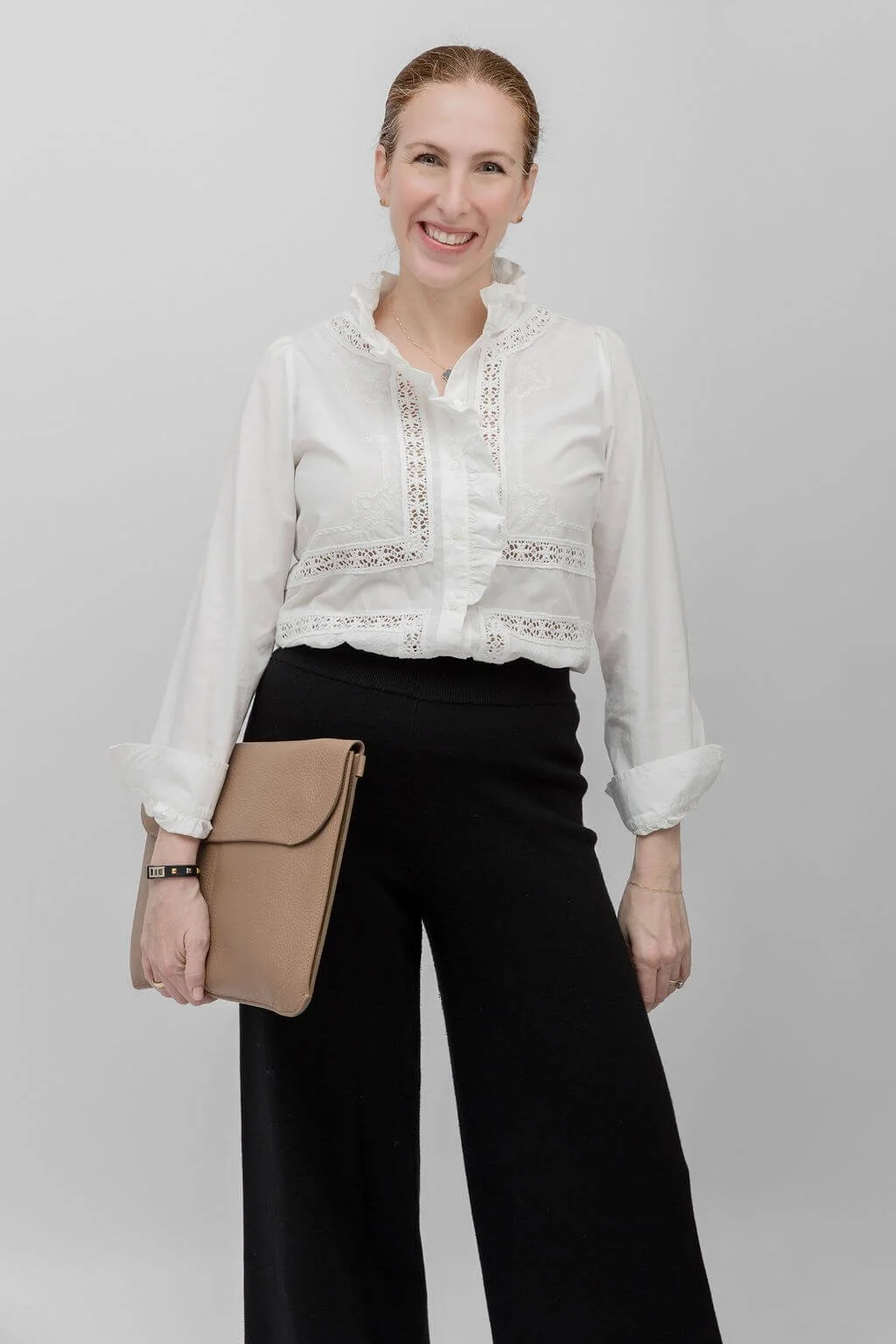 Karen Hamou, MBA admissions consultant, smiling in a white blouse and tailored black pants