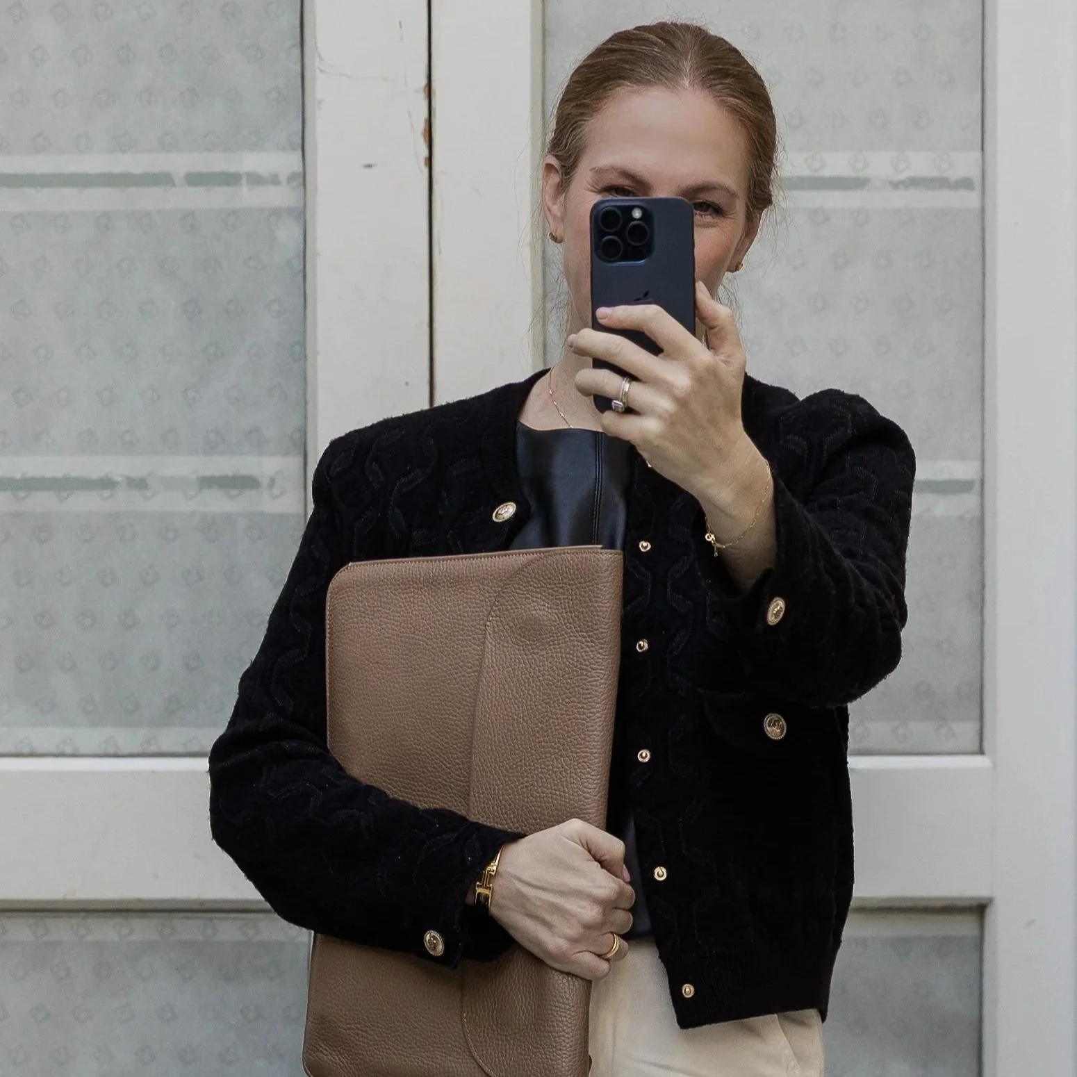 Karen Hamou, MBA admissions consultant, standing beside a window with white shutters