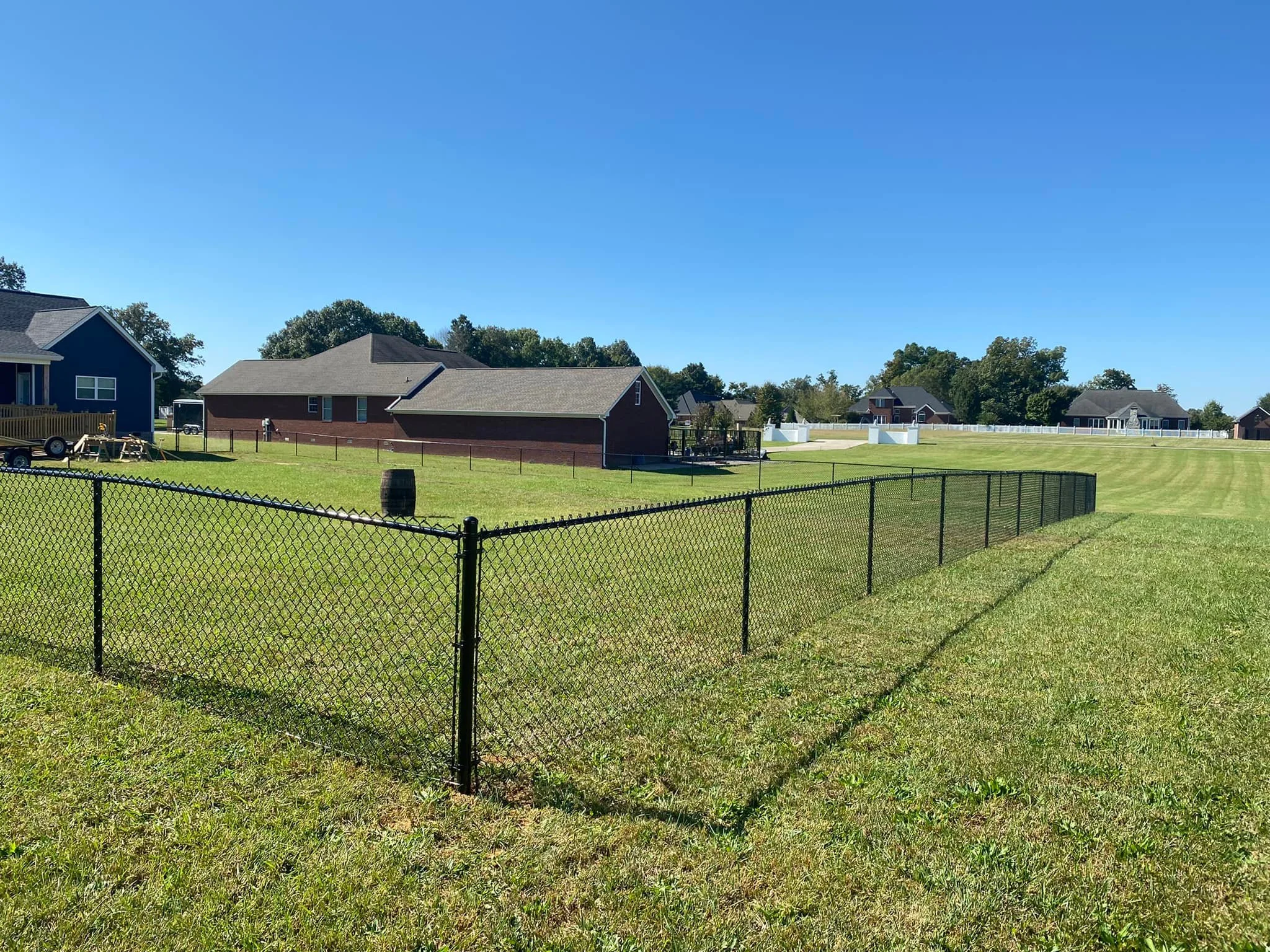 Residential backyard with a black chain-link fence built by Heritage Fence serving Paducah, Murray, Mayfield, Benton, Cadiz, Kentucky, Union City, Paris, Tennessee and Metropolis, IL