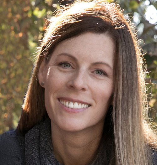 Dawn Mercado smiling outdoors with sunlight on her hair.