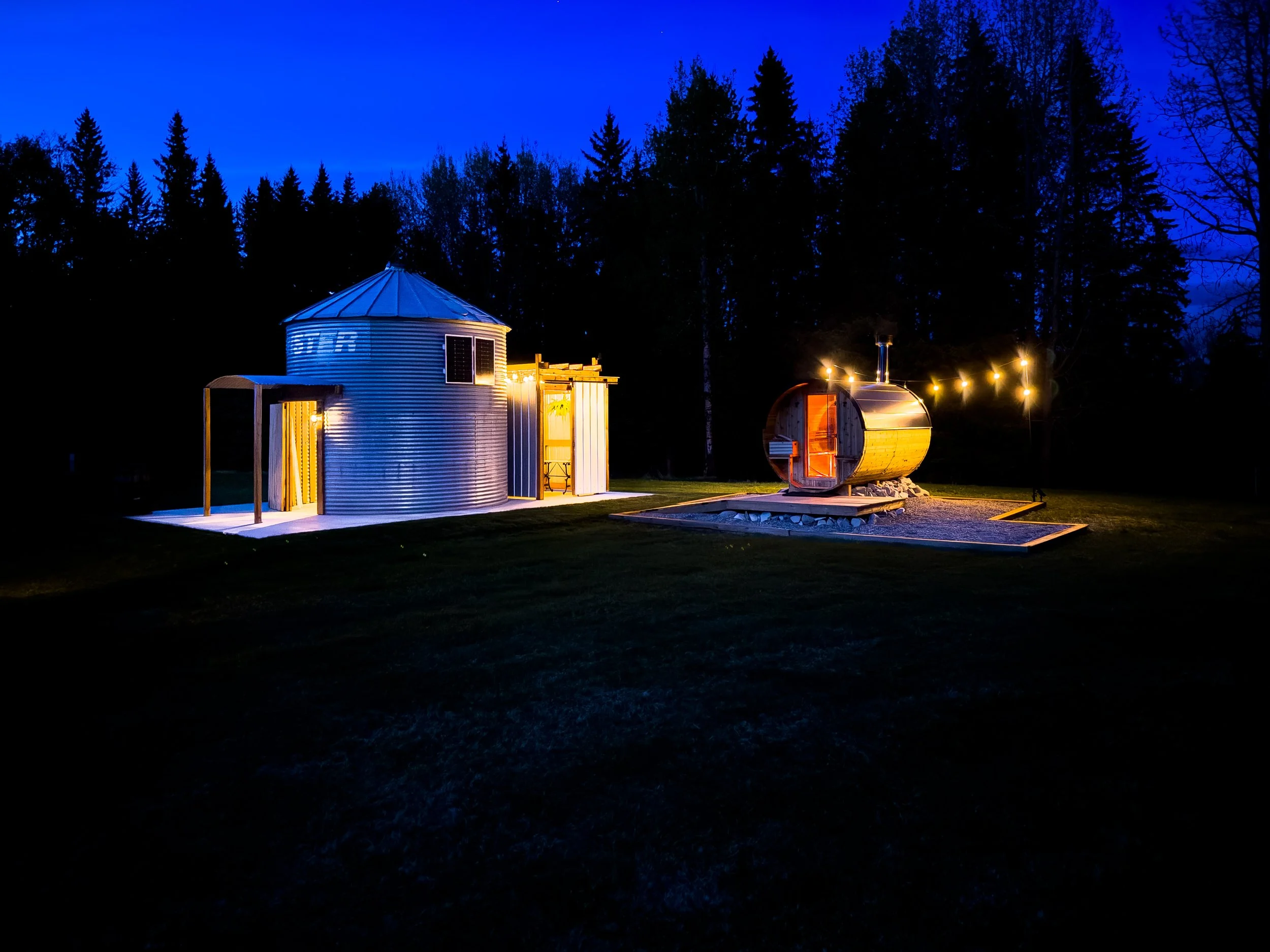6 person wood fired barrel sauna at night with edison  lights
