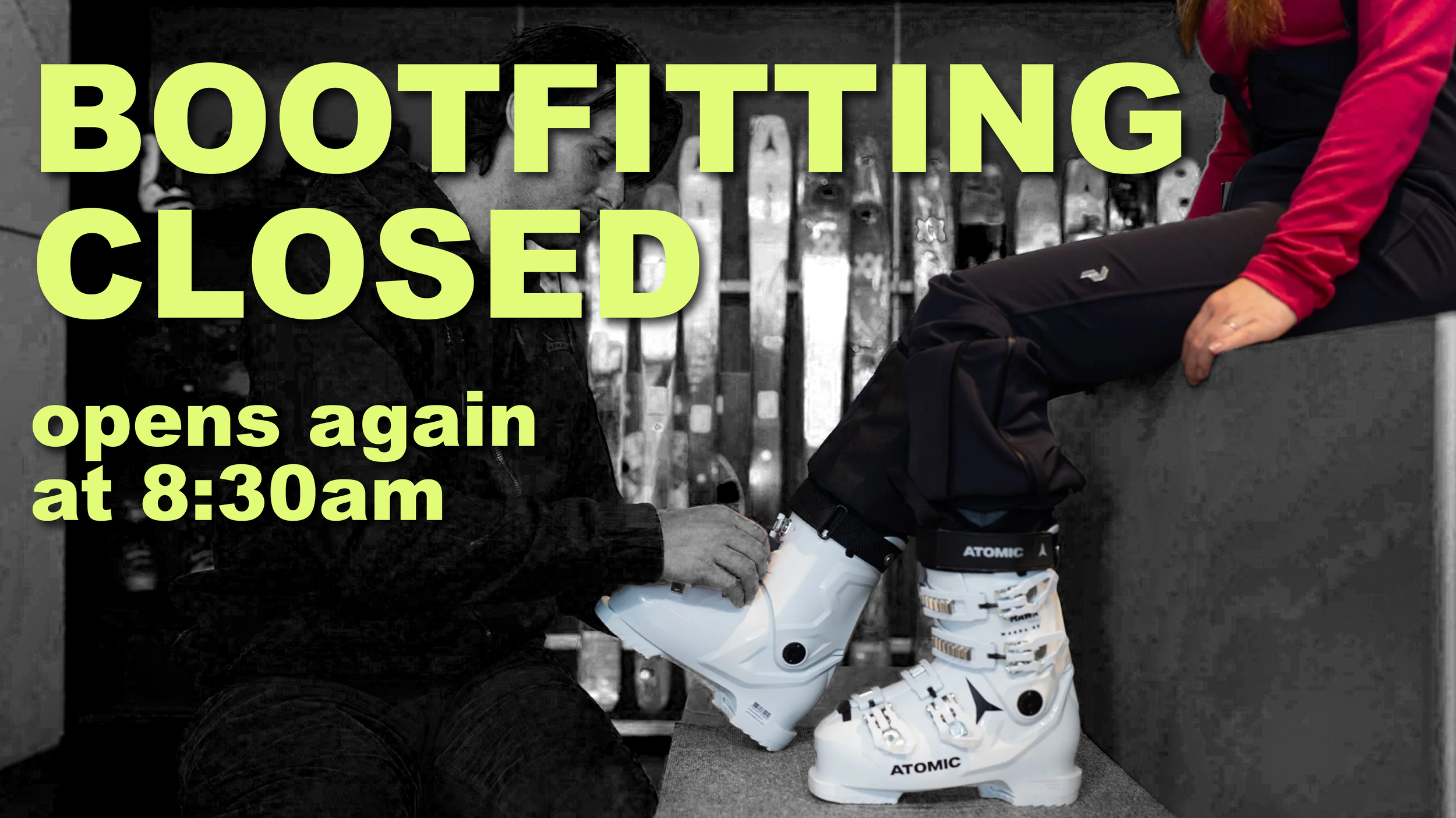 A person sitting on a ledge as another person helps them put on ski boots. The background features a black fence or gate, likely in a ski resort or locker area. Overlaid text reads, 'Bootfitting closed, opens again at 8:30am.'