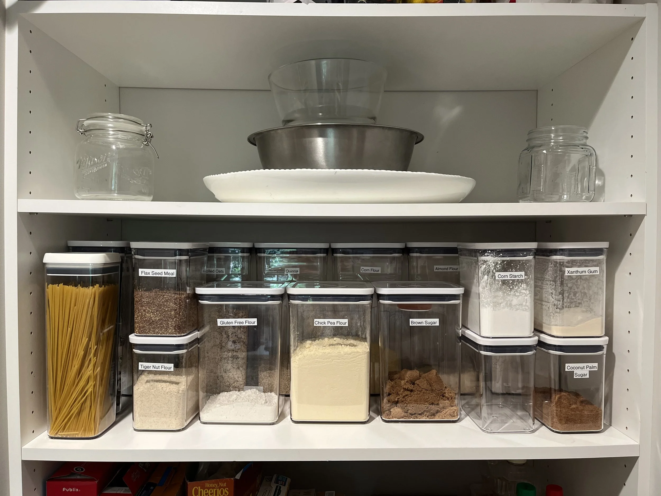 Organized Atlanta kitchen pantry with labeled containers of various dry ingredients. Clear bins are best for ADHD organizing near Decatur, GA. 