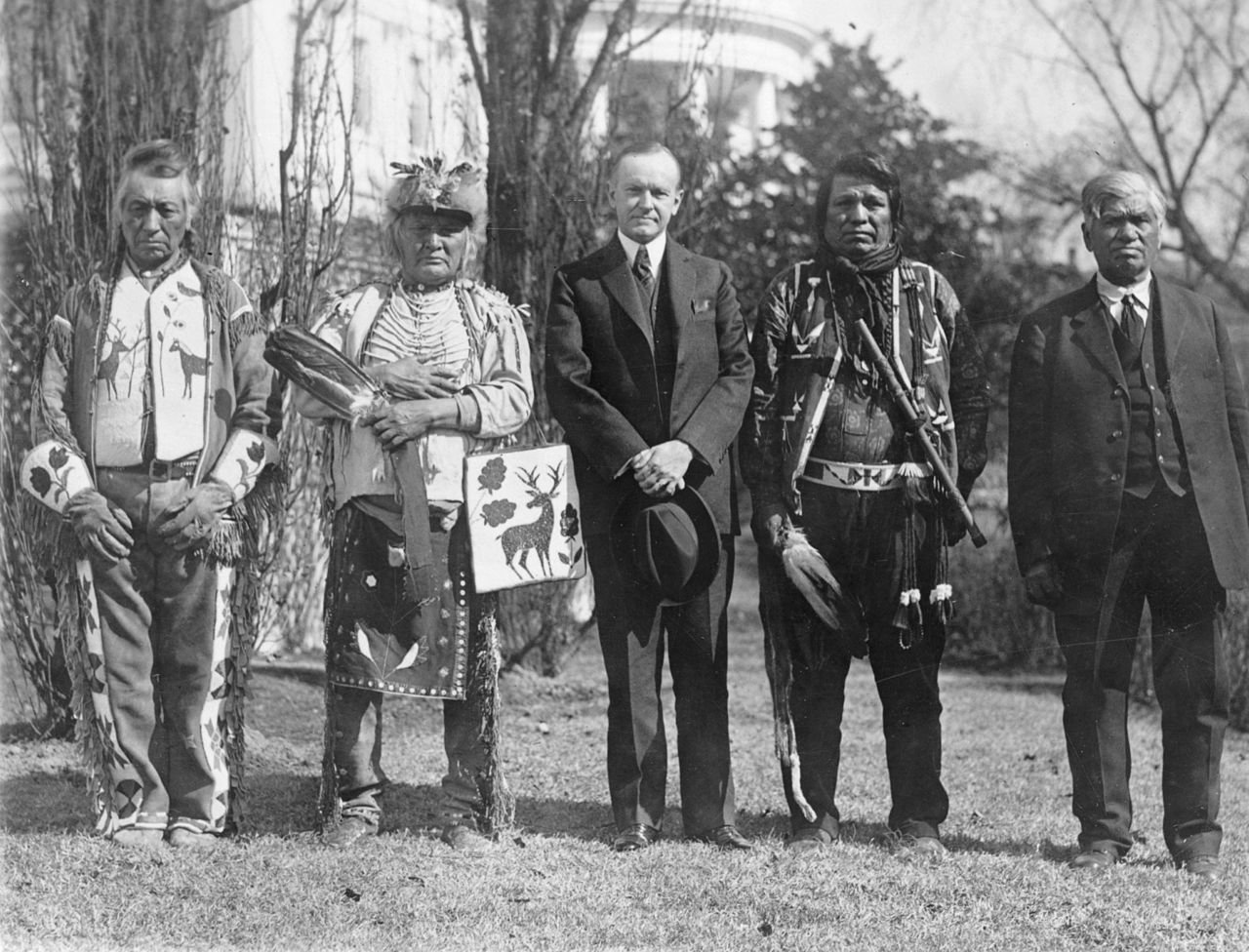 President Calvin Coolidge standing with members of the Osage Tribe