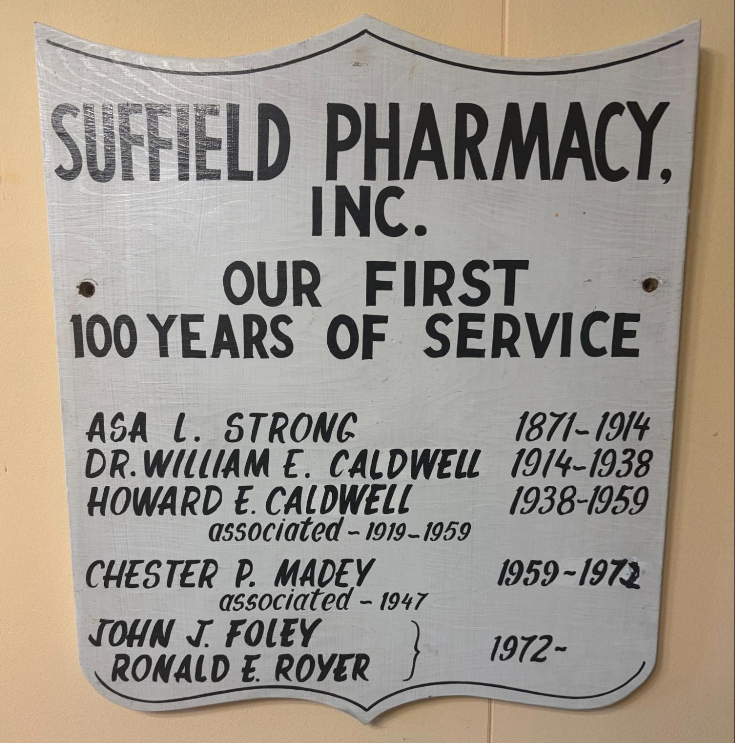 A sign celebrating the Suffield Pharmacy Centennial that is on display at Academy Hall