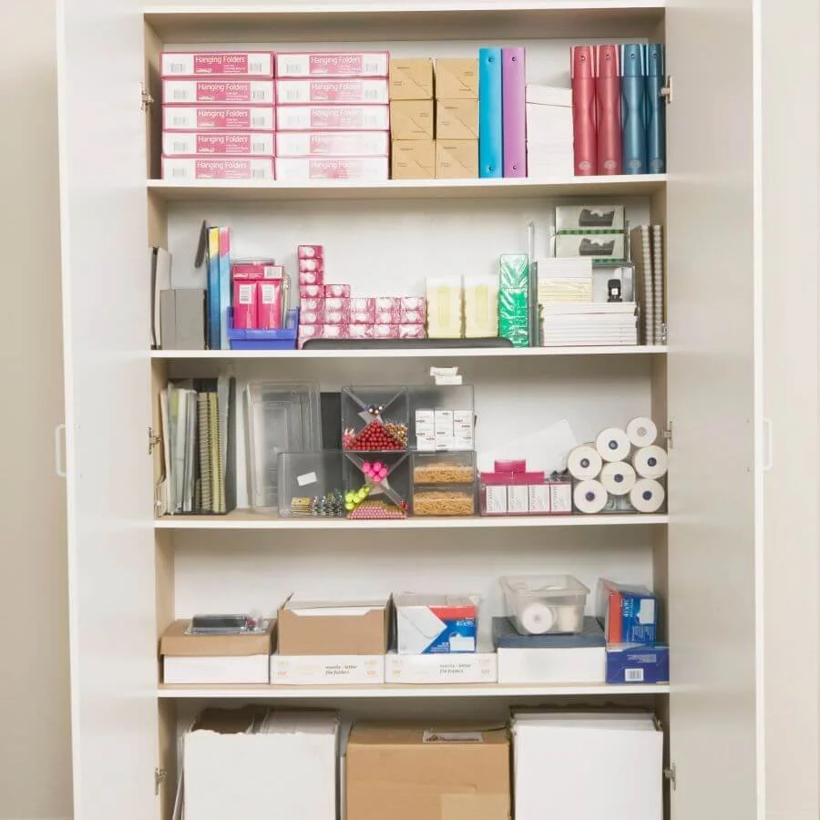 Organized office supply storage cabinet with paper, binders, envelopes, and everyday business supplies arranged for easy access.