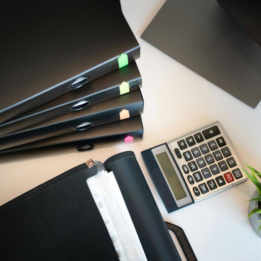 Organized filing and administrative system with labeled binders, paperwork, office supplies, and tools for efficient business operations.