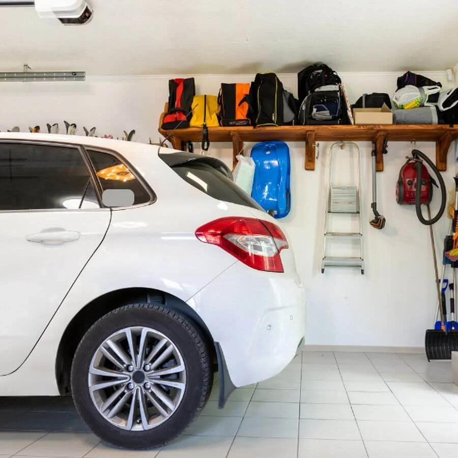 Organized garage with a vehicle parked inside, clear floor space, and functional storage areas.