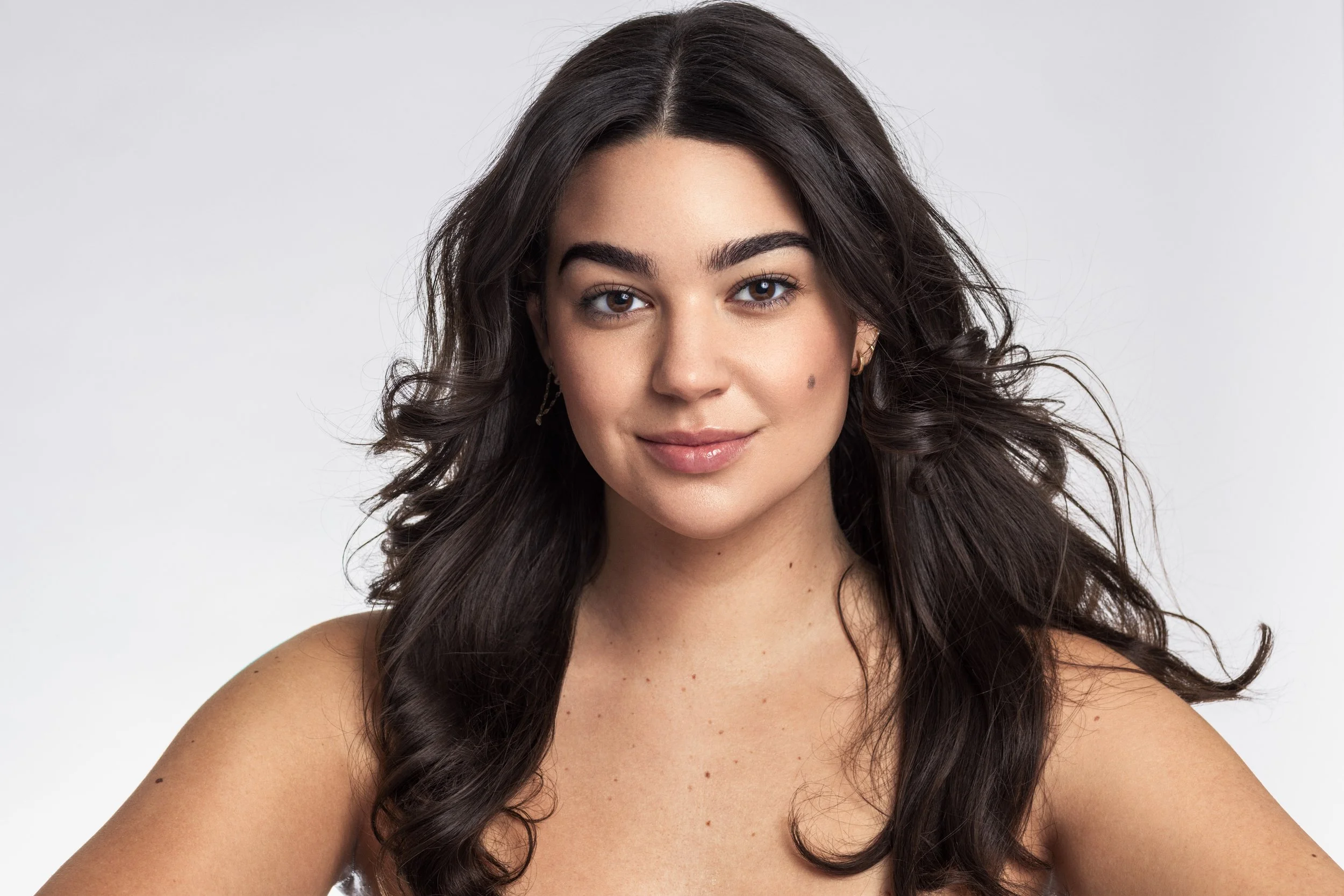 A clean beauty portrait of a young hispanic women on a studio gray background for a cosmetics brand in Austin, TX