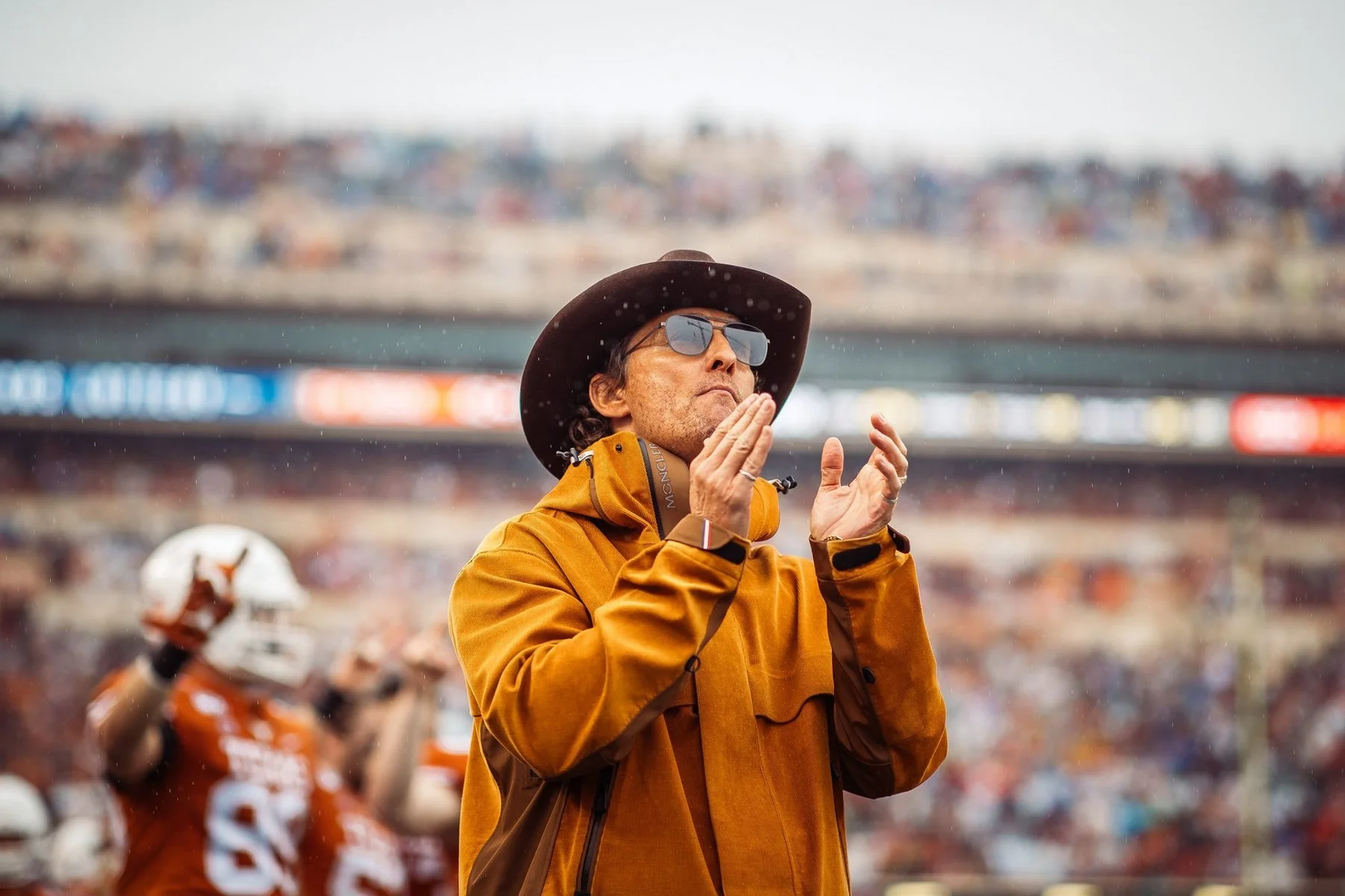 A portrait of Matthew McConaughey clapping on the sideline of a Texas Football game in Austin, TX