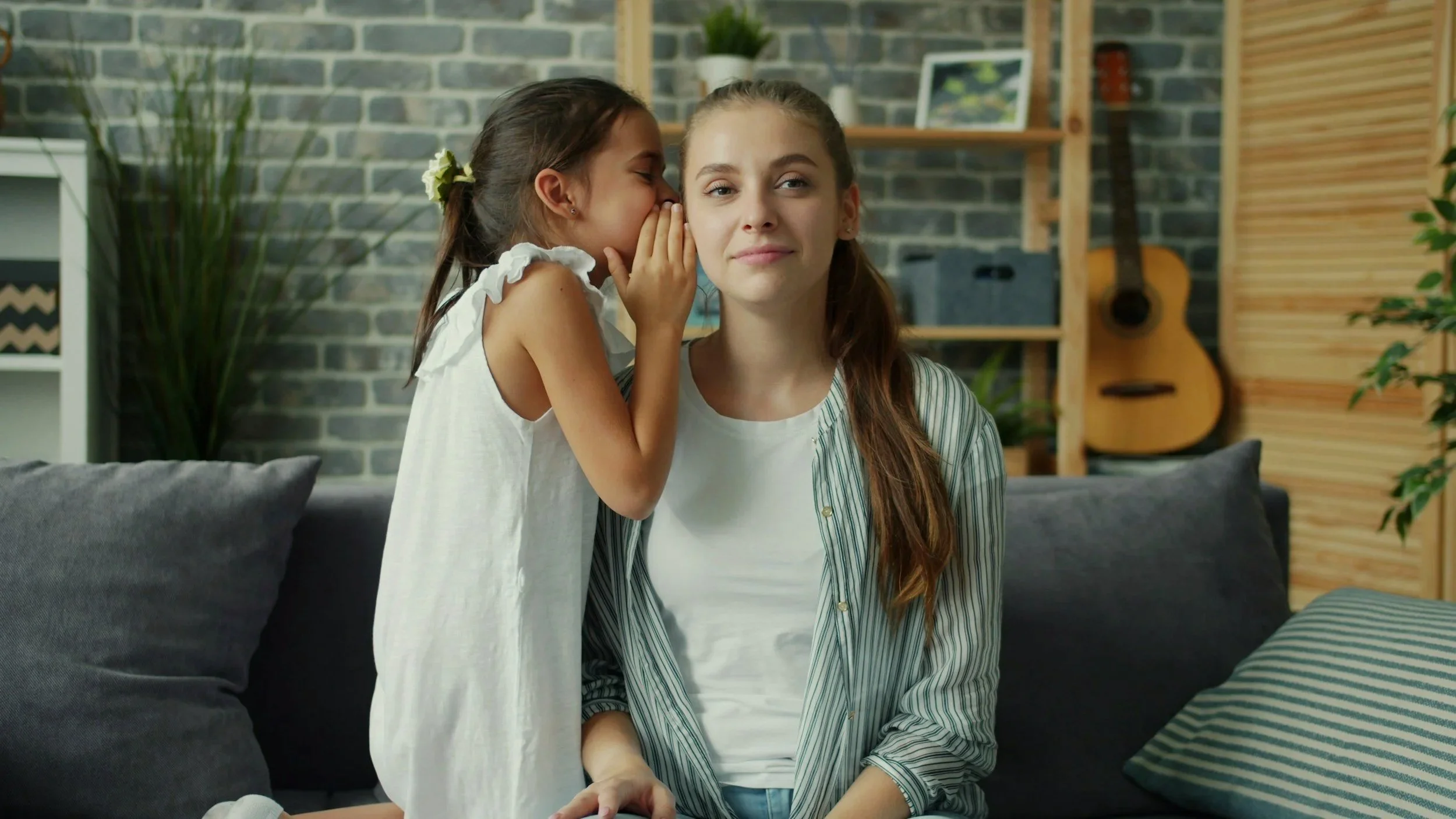 A child whispers to their parent, a common behavior in selective mutism, highlighting the importance of supportive, evidence-based therapy