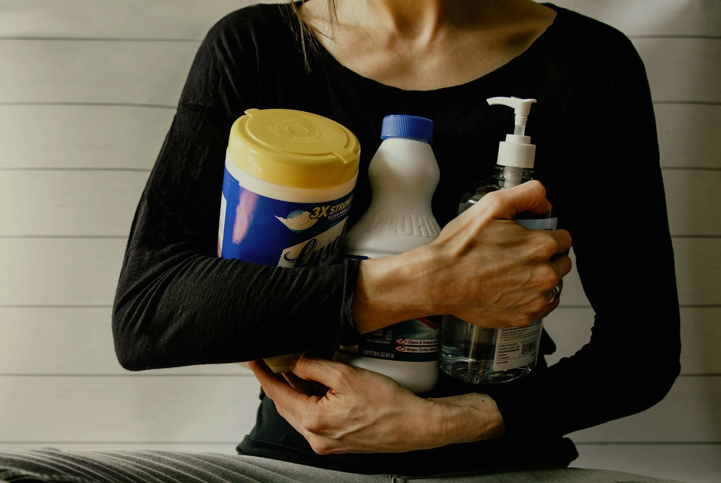 A woman holding cleaning products, representing the compulsive cleaning rituals and contamination fears associated with contamination OCD treated at Austin Anxiety and OCD Specialists in Austin and Round Rock, Texas.