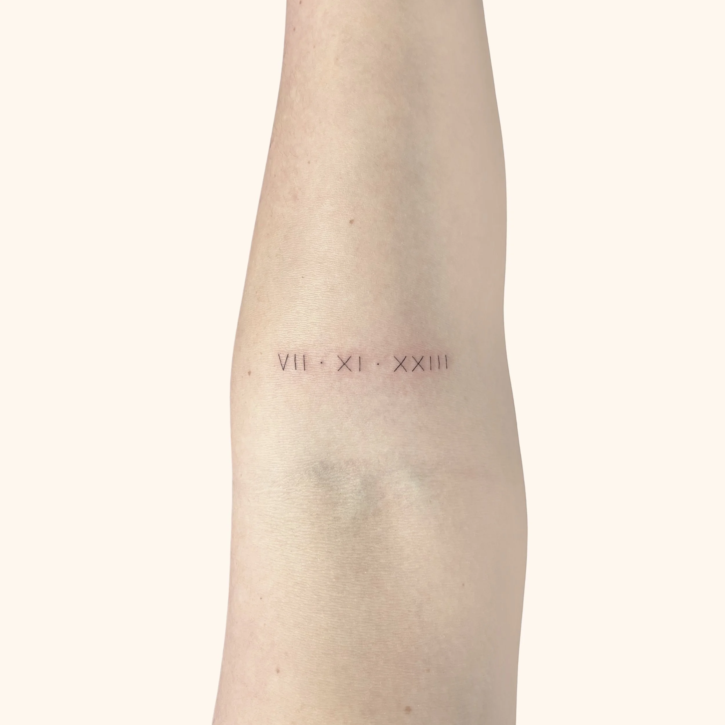 "VII XI XXIII" print script tattoo in capital letters inked in Victoria BC