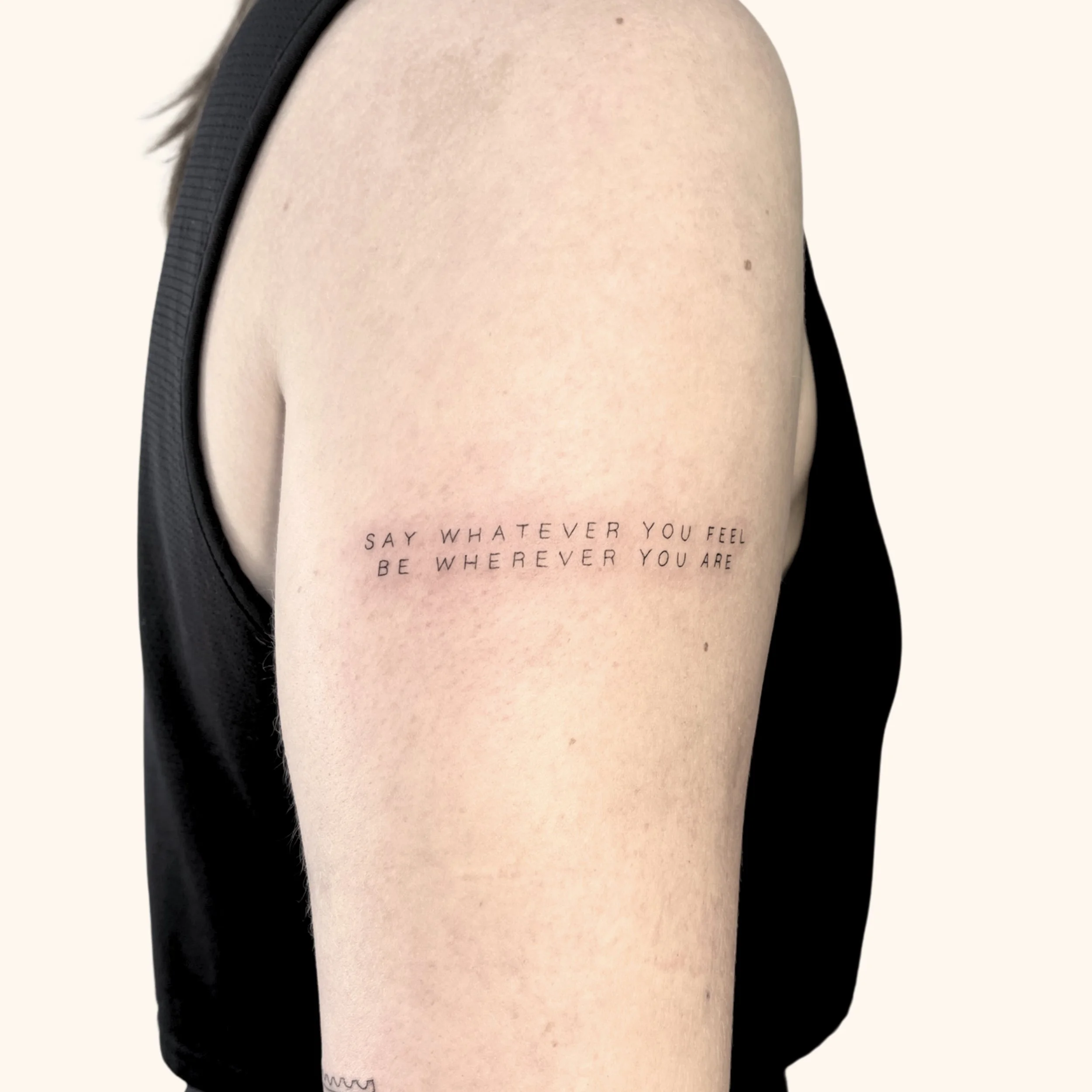 fine line Noah Kahan inspired script tattoo by  Fine Line Laurie in Victoria British Columbia on a person's shoulder "Say whatever you feel, be whatever you are" in captial sans serif font