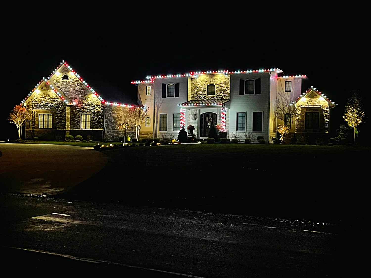 Tri-City Lighting holiday installation outlining a home’s roofline, windows, and columns
