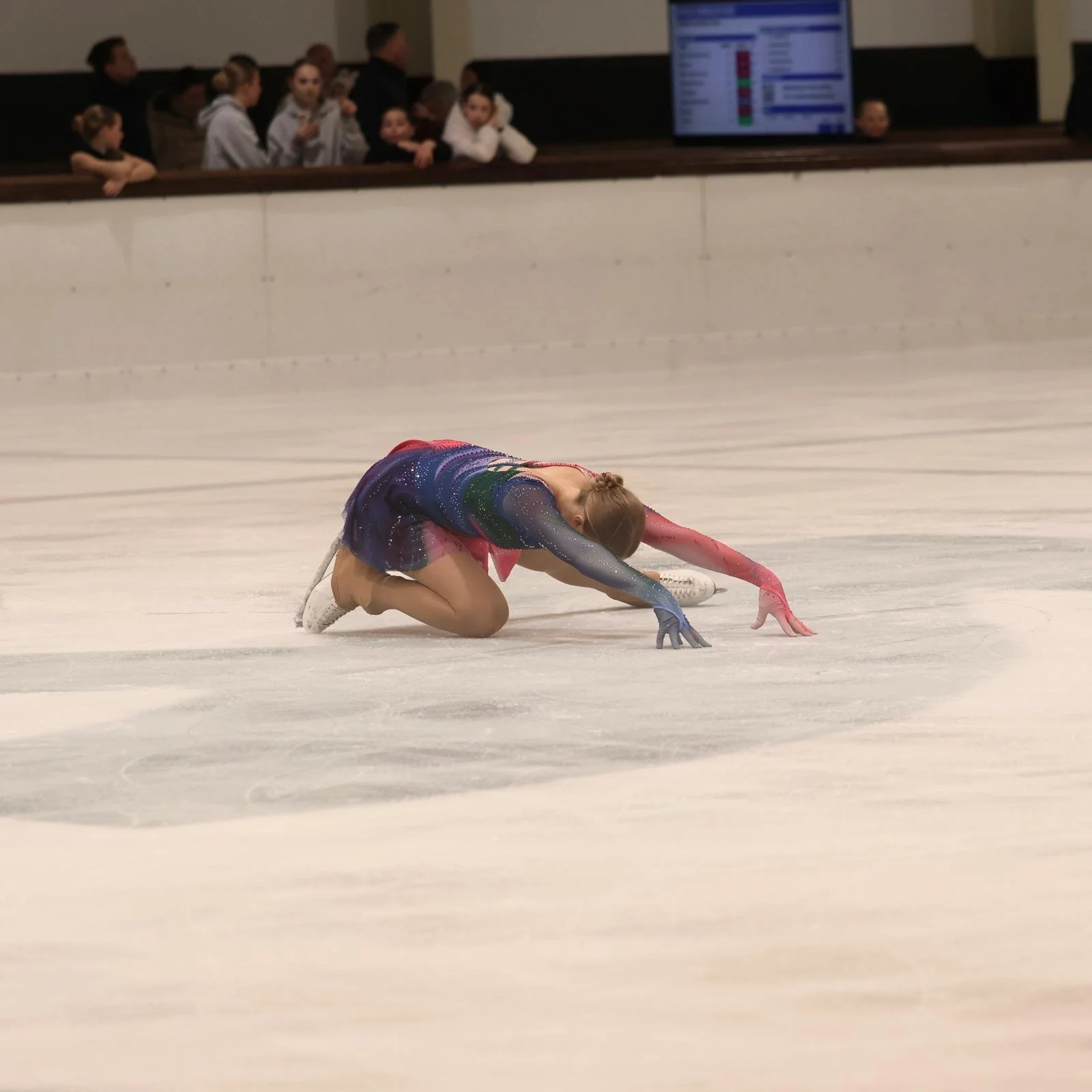 Schaatster op ijs in beginpose met kleurrijk pakje van Atelier Nadja & Tutti Leotards