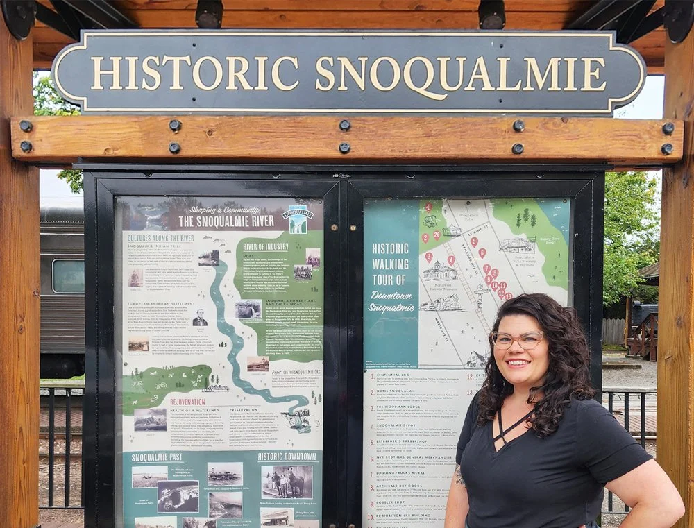 Historic Snoqualmie educational poster and map design kiosk, with designer Kat Marshello proudly standing in front