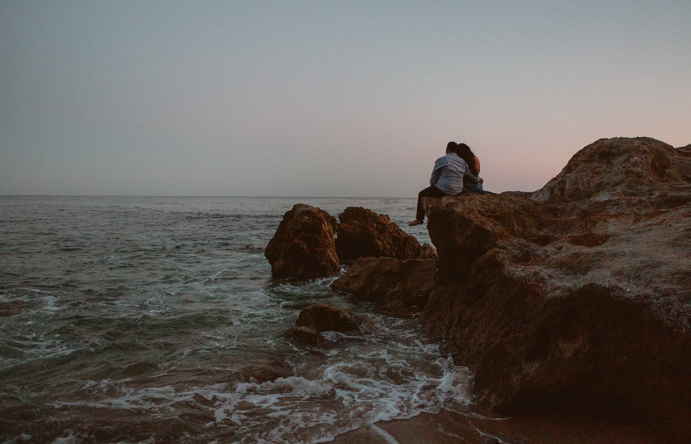 sunset at laguna beach on the rocks engagement session