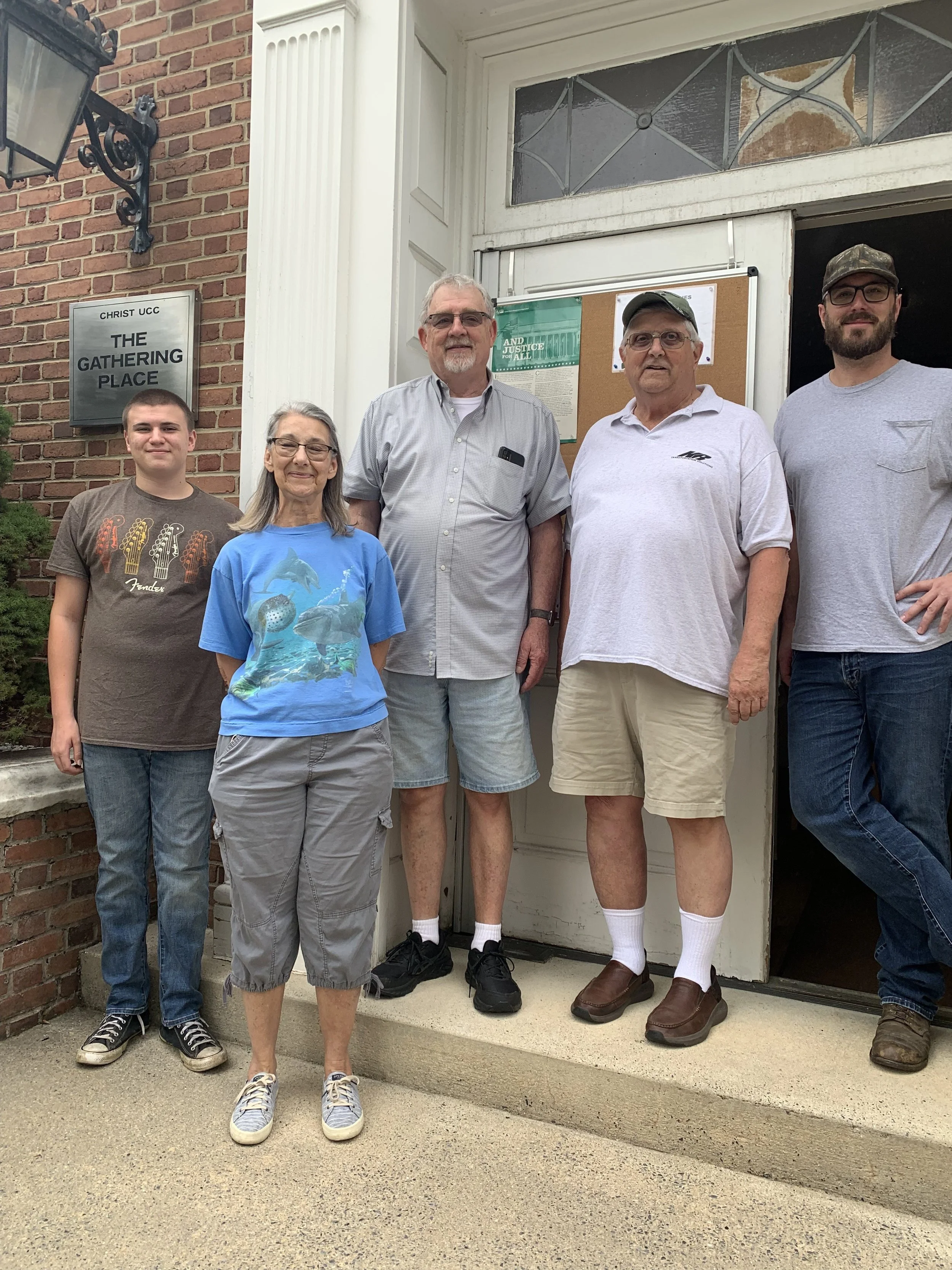 A group of six people standing outside a building labeled "The Gathering Place."