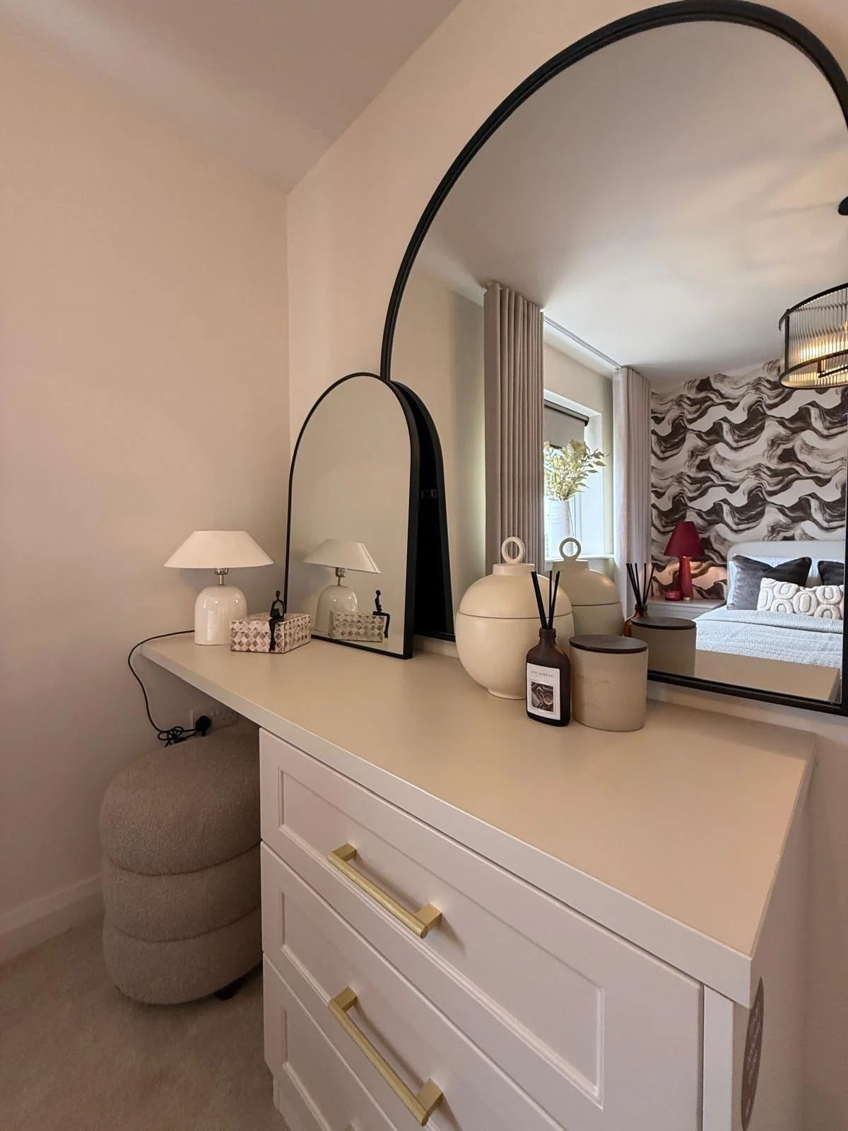 Show home principal bedroom at Hafan y Glyn, Colwyn Bay, with alabaster globe chandelier, wave curtains and layered cream and damson bedding