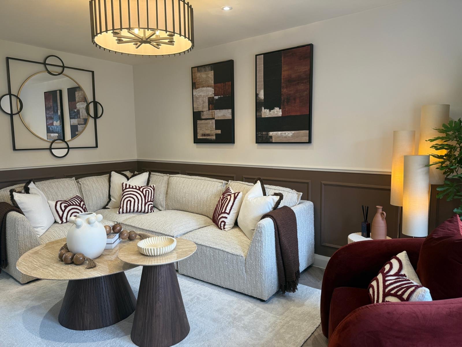 Open-plan dining area with marble-topped table, boucle chairs and walnut media wall at the Hafan y Glyn show home in Colwyn Bay
