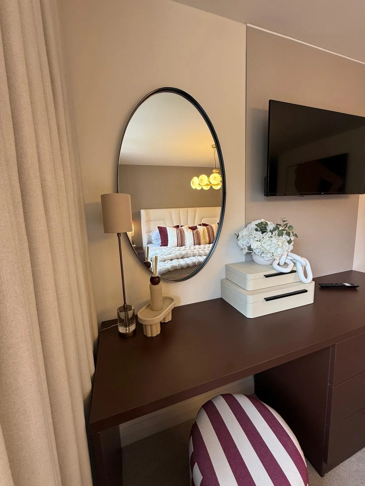 Show home principal bedroom at Hafan y Glyn, Colwyn Bay, with alabaster globe chandelier, wave curtains and layered cream and damson bedding