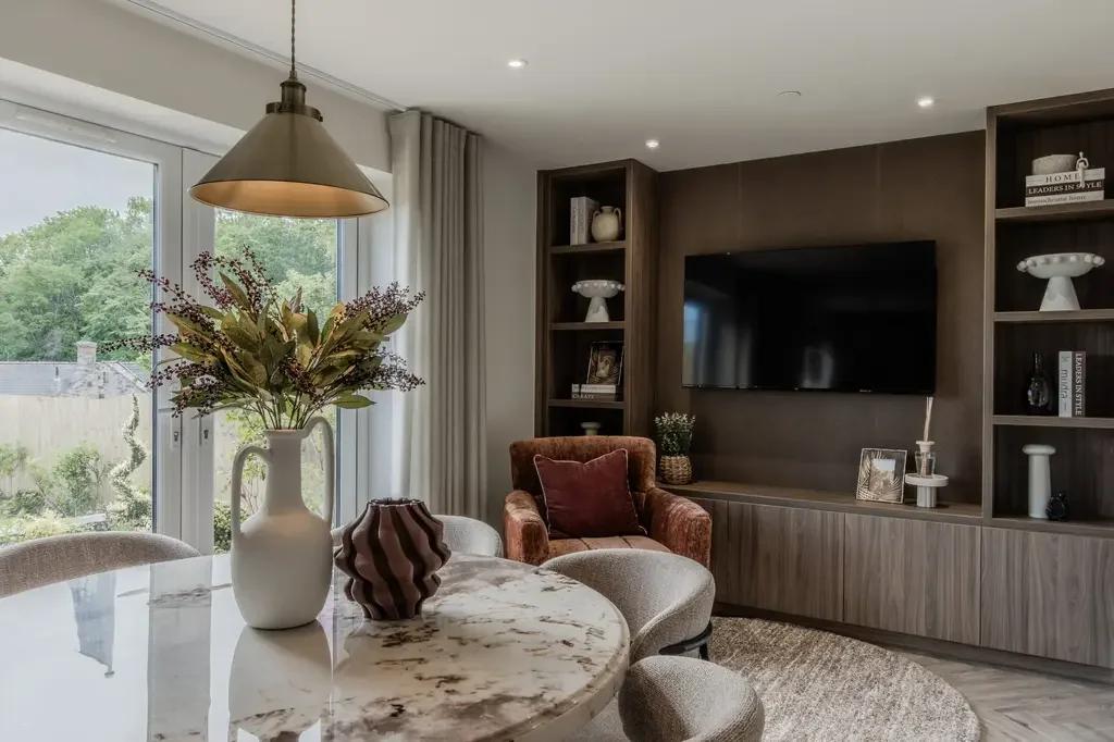 Show home living room interior design featuring cream boucle corner sofa, brown wall panelling and rust velvet armchair