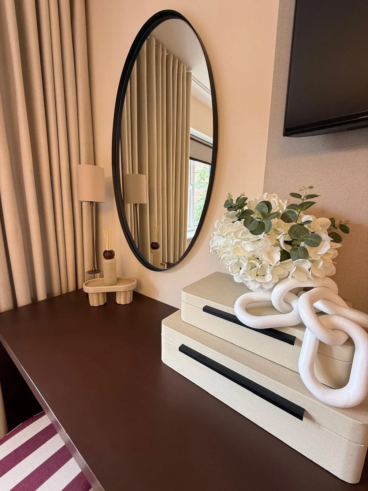 Show home principal bedroom at Hafan y Glyn, Colwyn Bay, with alabaster globe chandelier, wave curtains and layered cream and damson bedding
