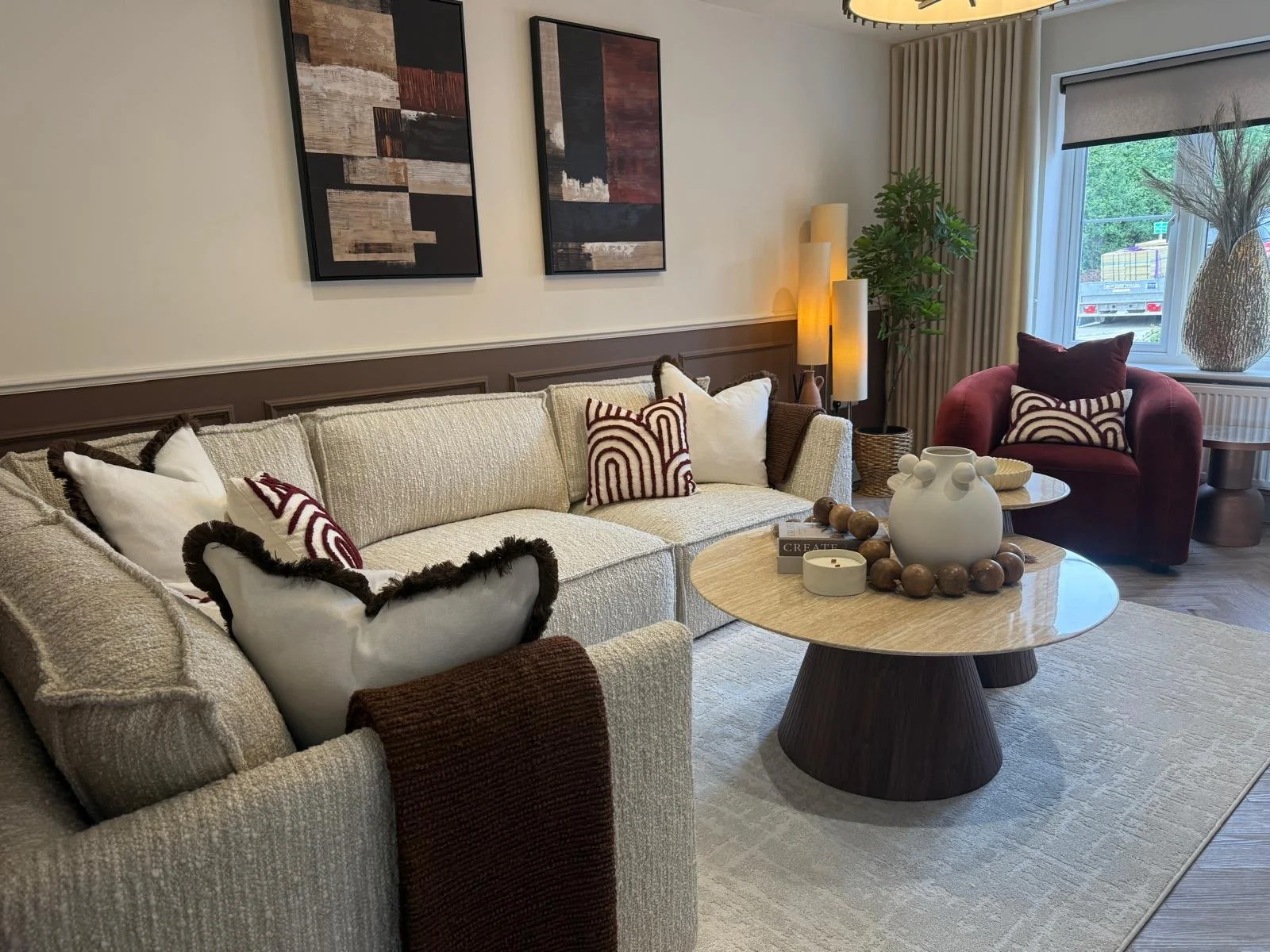 Show home living room interior design featuring cream boucle corner sofa, brown wall panelling and rust velvet armchair
