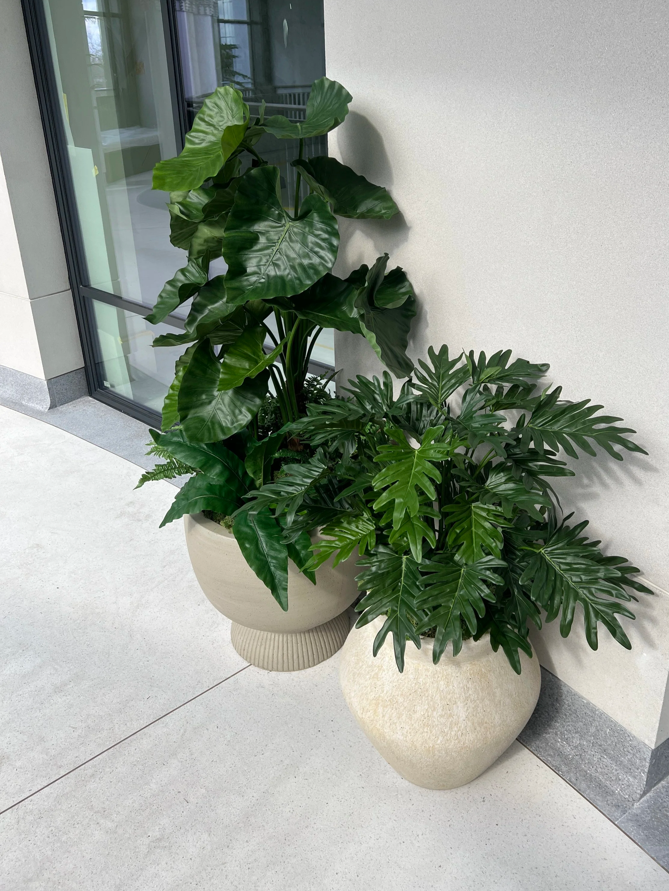 Indoor planted balcony area with replica plant displays.