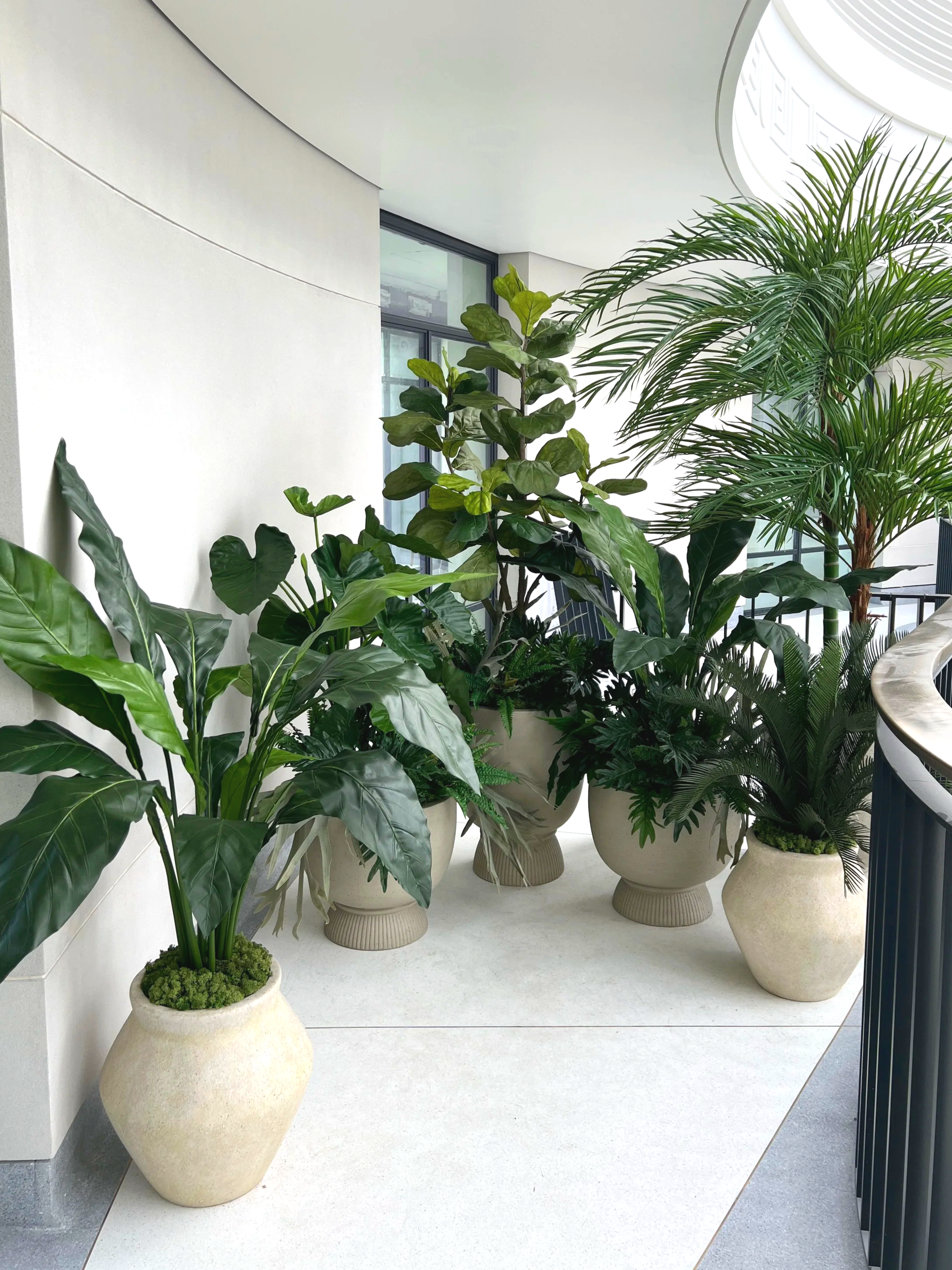 Indoor planted balcony area with replica plant displays.