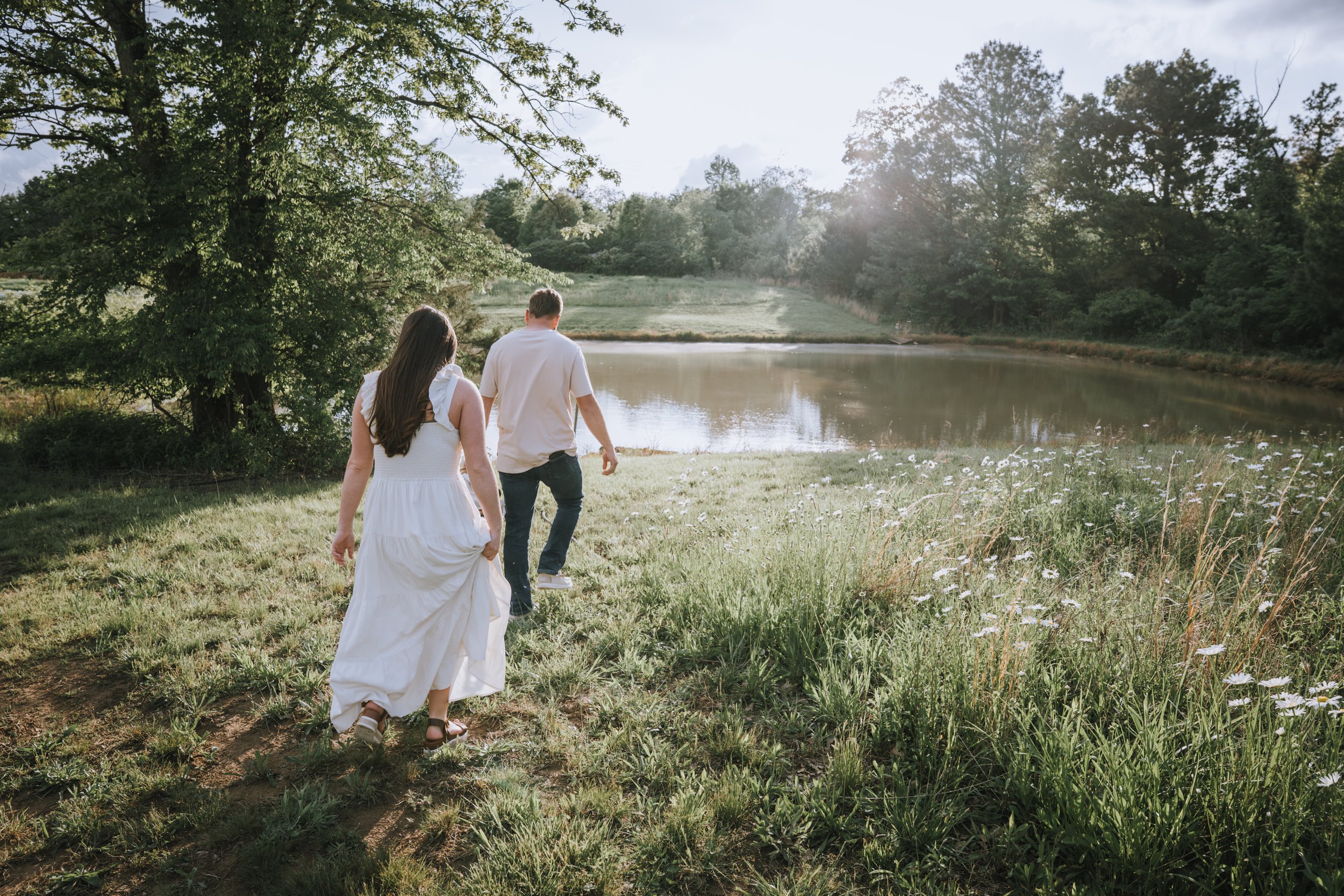 bride and groom walking in field during engagement photo session at Honey Hill Farms in Mayfield Kentucky