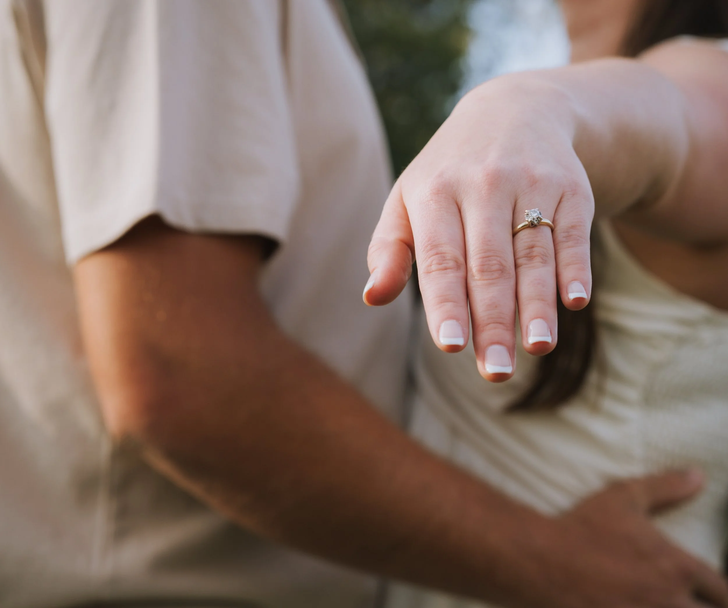couple in field showing engagement ring during engagement photo session at Honey Hill Farms in Mayfield Kentucky
