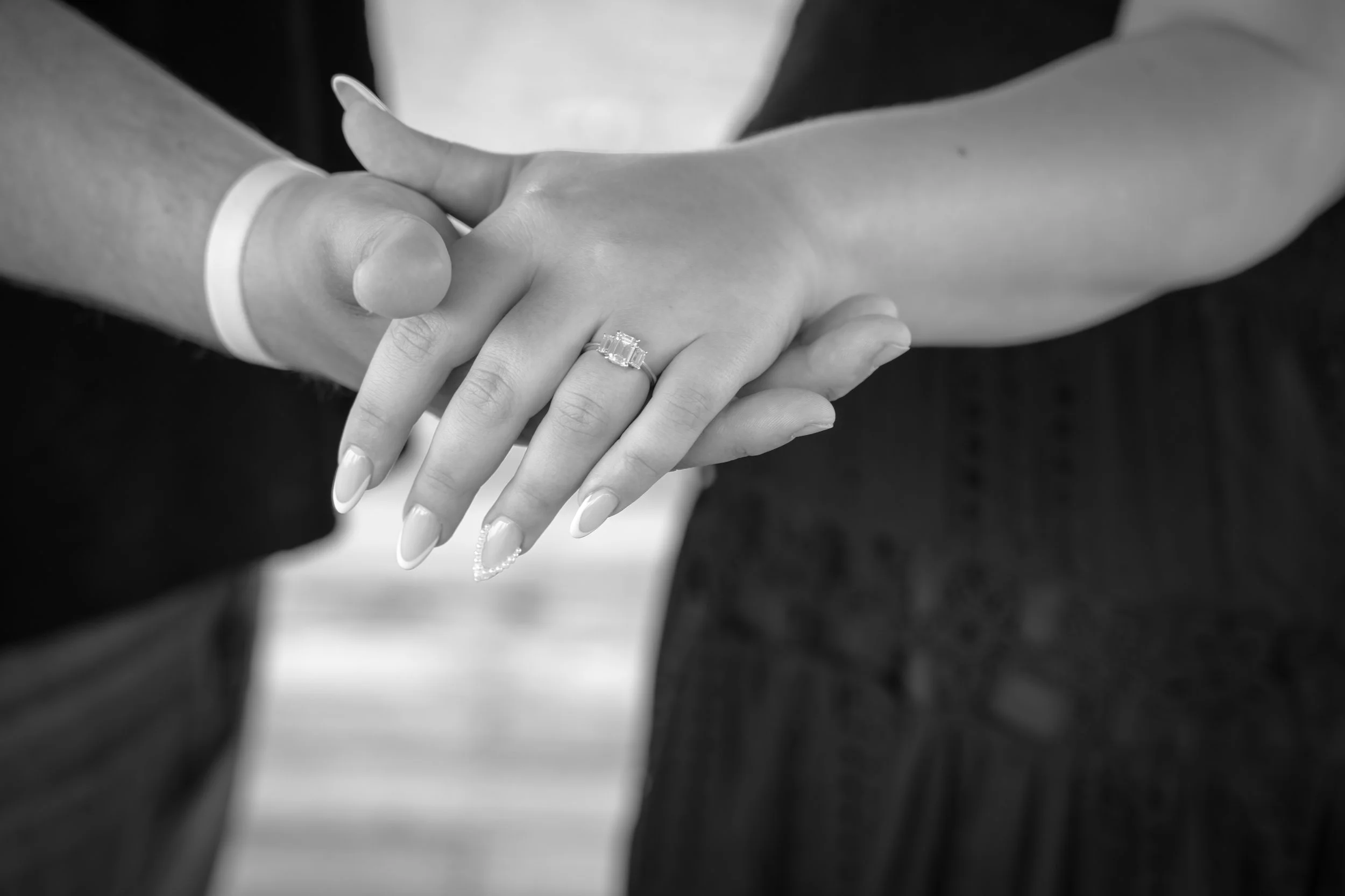 black and white photo of couple holding hands and displaying engagement ring during engagement photo session at Kenlake State Resort Park in Aurora Kentucky