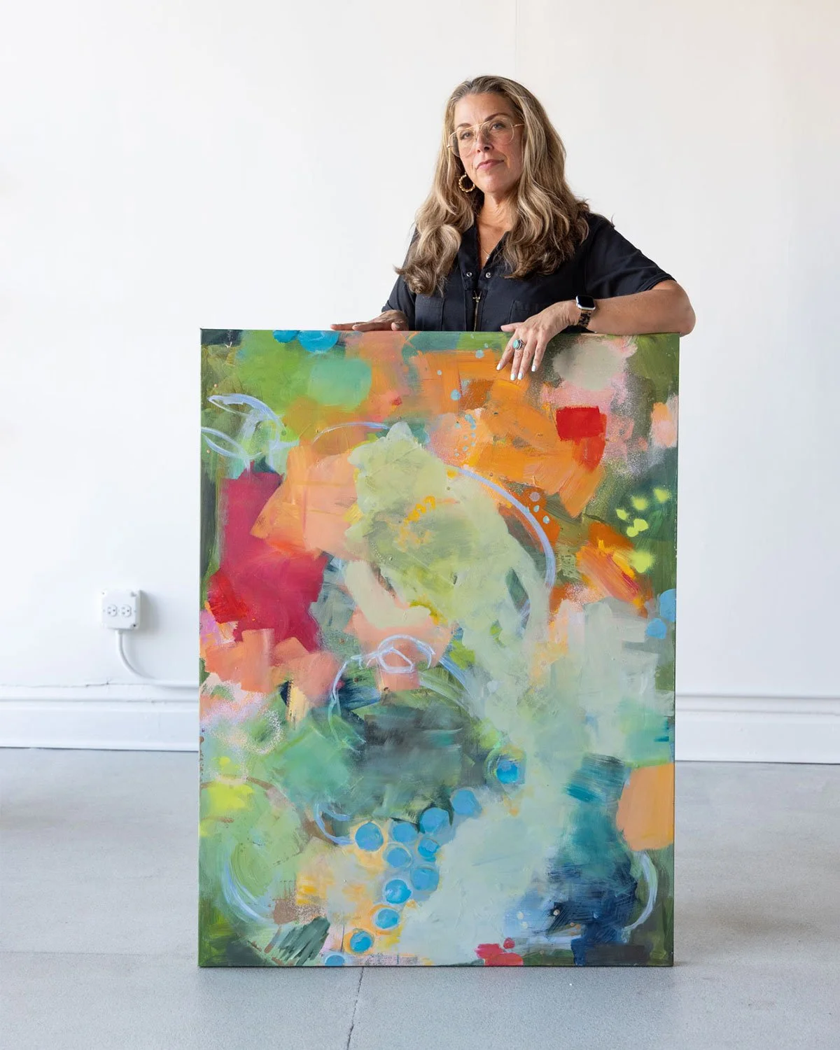 Heidi Becker abstract artist standing in gallery with painting