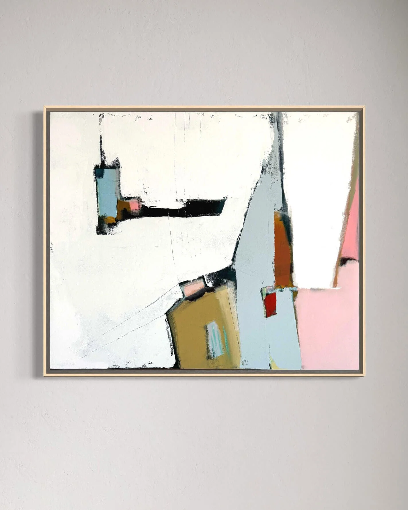 Abstract colorful painting by Karyn Denten with geometric shapes on a white canvas, framed and hung on a plain wall.